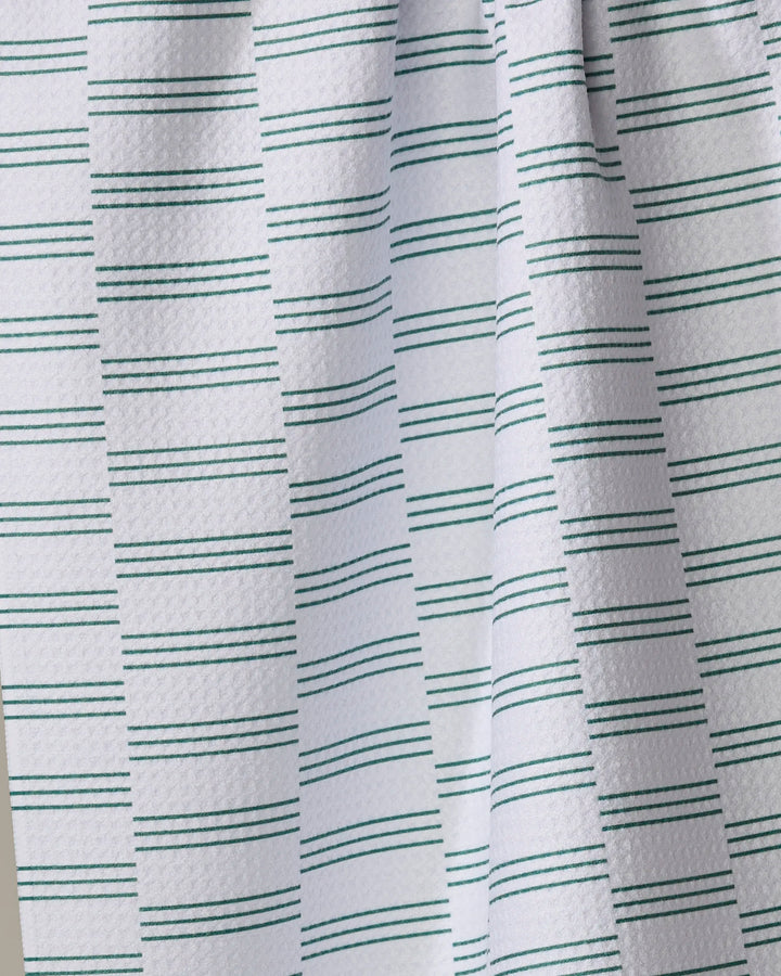 A close-up of The Buy Guide’s Small Stripe - Evergreen kitchen towel, showing its white textured fabric with thin green stripes—an eco-friendly choice for everyday use.
