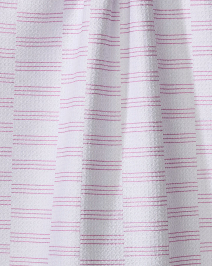 A close-up of The Buy Guide’s Small Stripe - Pink towel shows white textured fabric with evenly spaced pink stripes, a draped look, and subtle shadows highlighting the ultra-absorbent material.