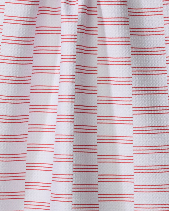 The Buy Guide’s Small Stripe - Red kitchen towel features eco-friendly white textured fabric with paired horizontal red lines in a simple geometric pattern, draped to show gentle vertical folds and subtle shadows.