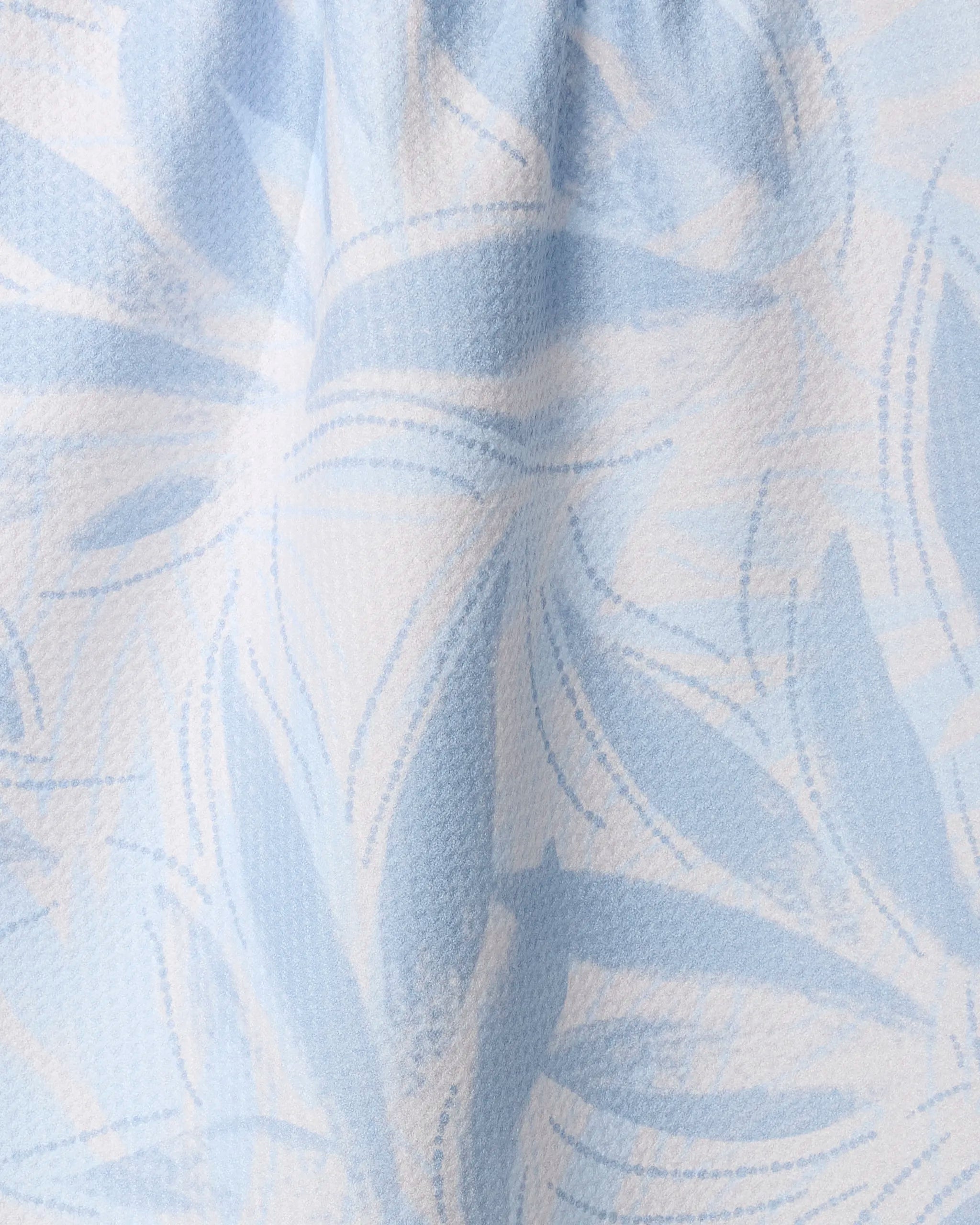 Close-up of Geometry’s Soft Breeze tea towel: ultra-absorbent, light blue and white with an abstract leafy pattern, overlapping curved lines, and soft shapes in varying blue shades on a slightly textured surface.