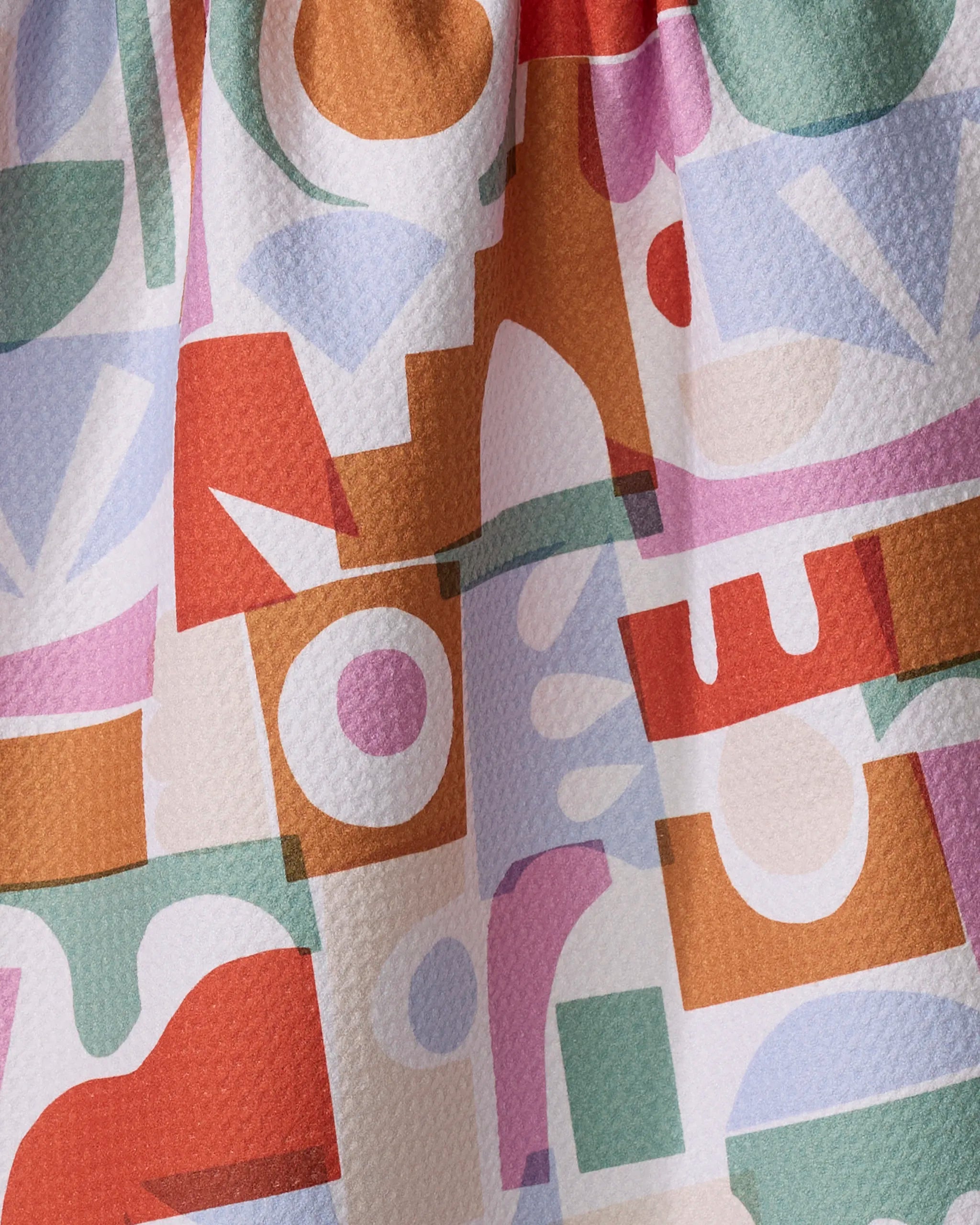 Soft Cutouts Garden by Claire Iglesias is a recycled kitchen towel with colorful abstract circles and rectangles in orange, green, pink, purple, and beige on a textured surface—bringing sustainable style to your home.