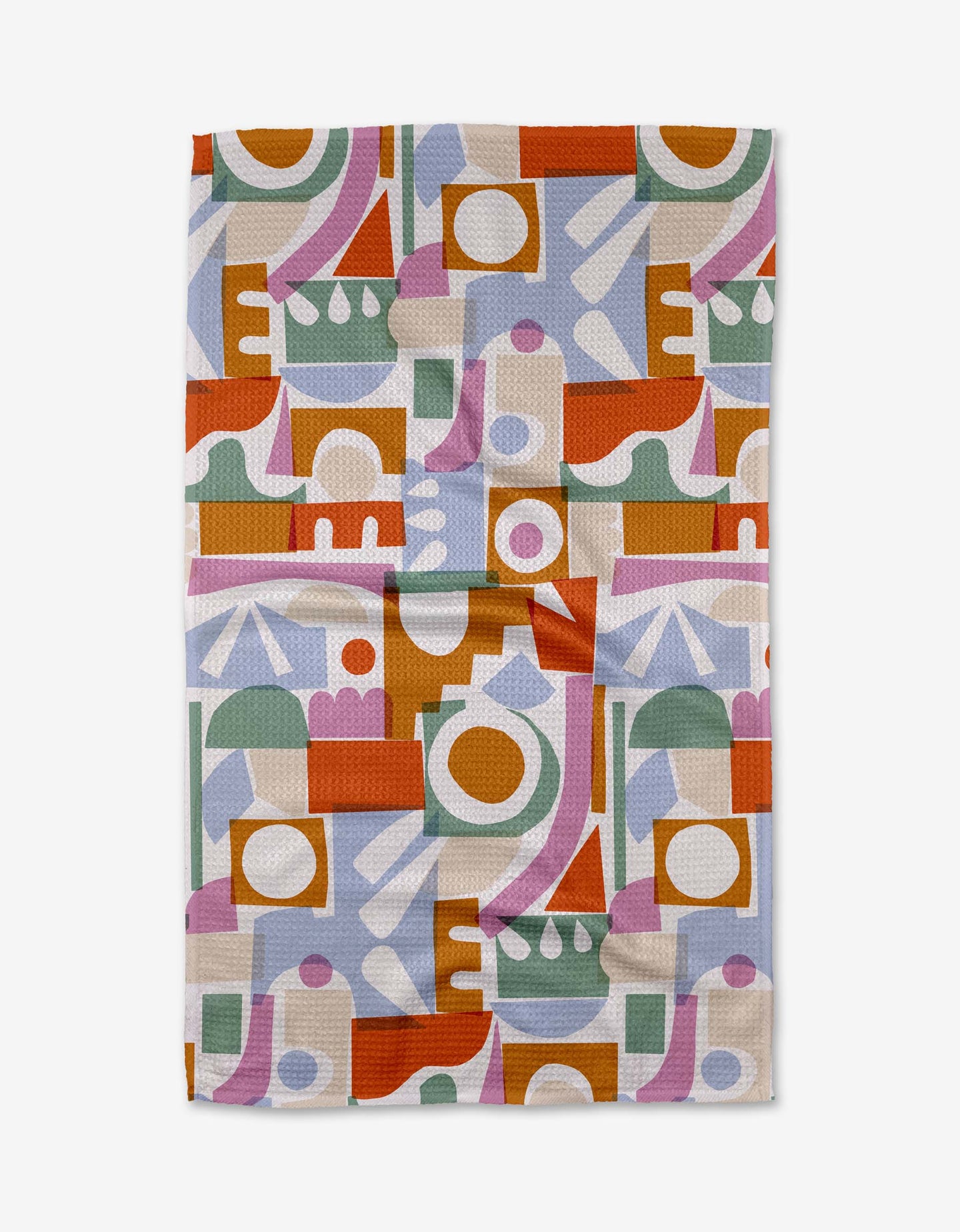 The Claire Iglesias Soft Cutouts Garden tea towel features an abstract geometric pattern in green, orange, yellow, lavender, pink, and white. The slightly wrinkled towel is shown laid flat on a white background.