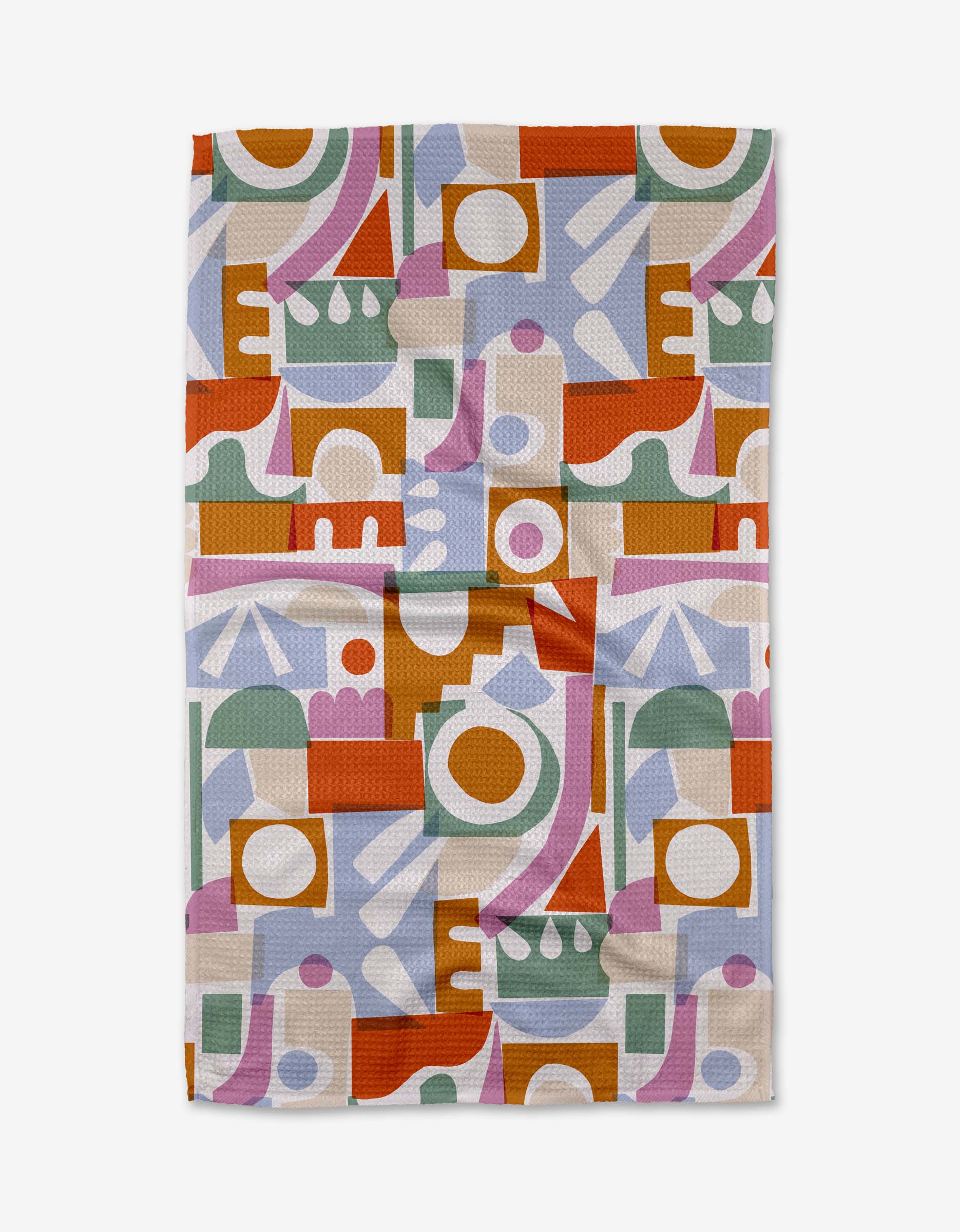 The Claire Iglesias Soft Cutouts Garden tea towel features an abstract geometric pattern in green, orange, yellow, lavender, pink, and white. The slightly wrinkled towel is shown laid flat on a white background.