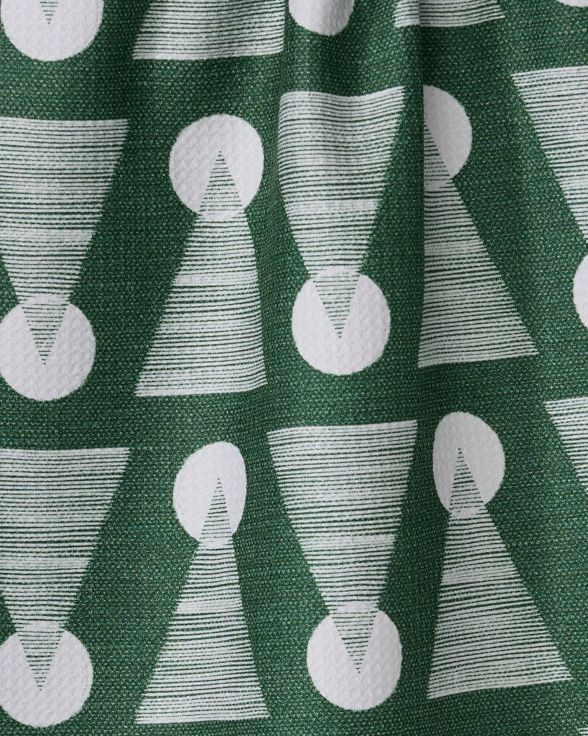 The Soltice Glow kitchen towel by Geometry features white, textured, striped triangles with solid circles on green recycled fabric. Absorbent and stylish, its gentle folds add to the modern design.