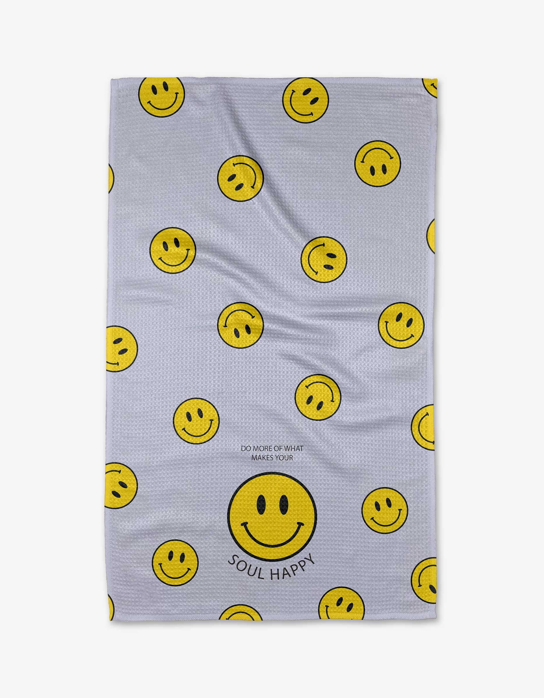 The “Soul Happy” tea towel by Quotes by Christie features multiple yellow smiley faces and a large one at the bottom, made from soft Geoweave™ fabric. SOUL HAPPY is printed below the large face, with DO MORE OF WHAT MAKES YOUR above it.