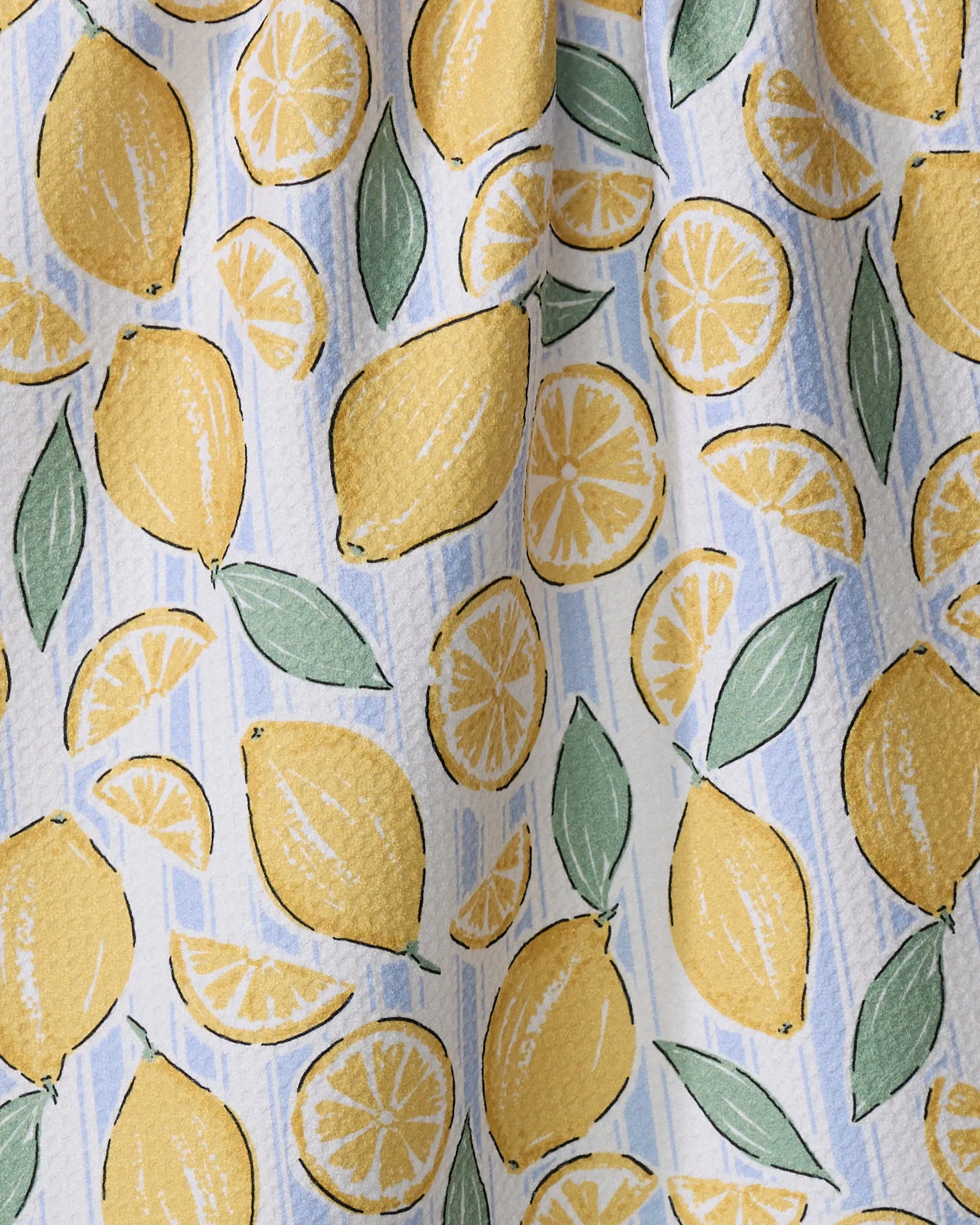 The "Sour Lemon Stripes" tea towel by Hufton Studio features fresh yellow lemons and green leaves on soft blue and white stripes—a vibrant, summery design.