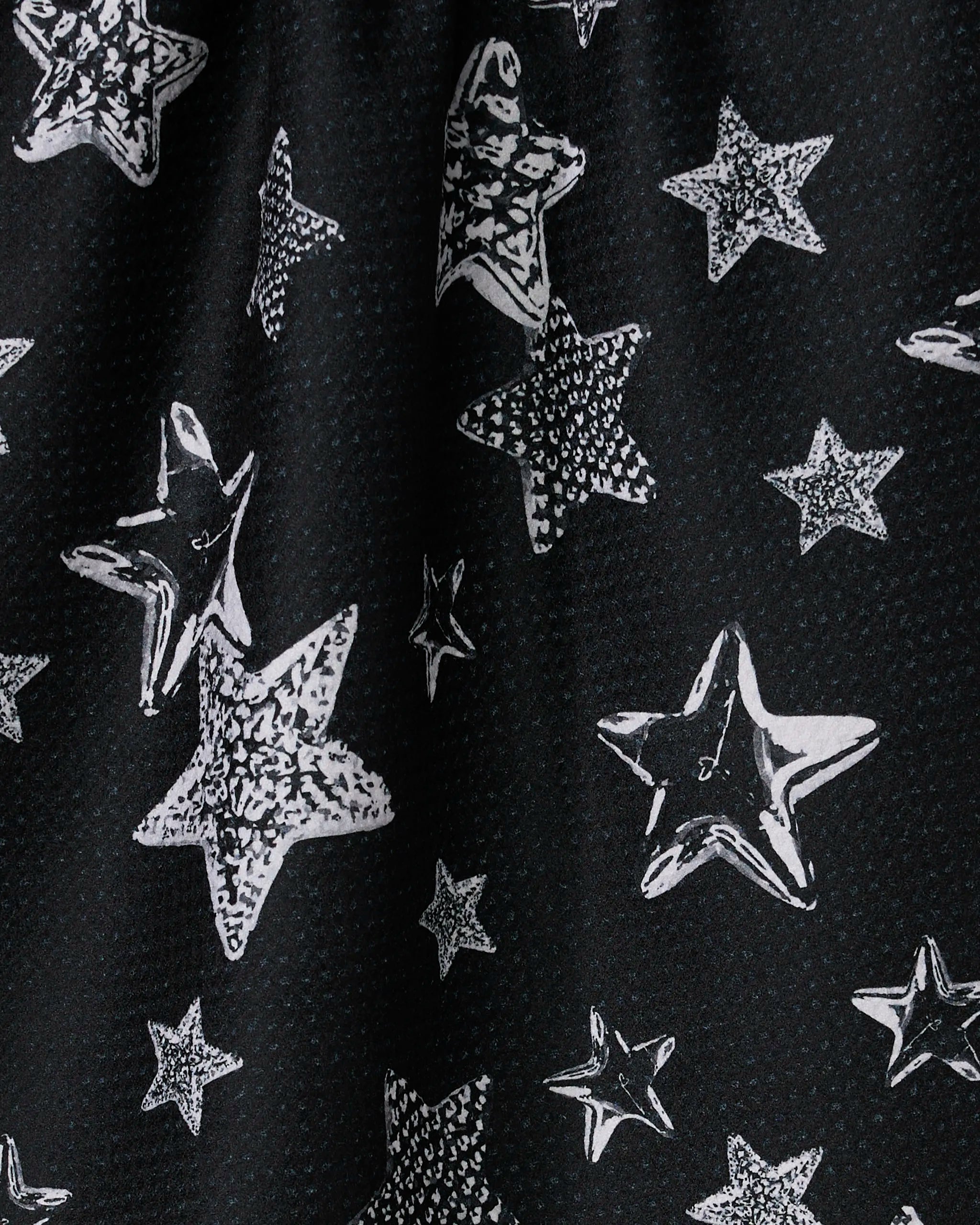 The Geometry "Sparkling Night" dish towel is black and absorbent, featuring white, irregular star patterns in various sizes for a playful, dynamic touch in your kitchen.