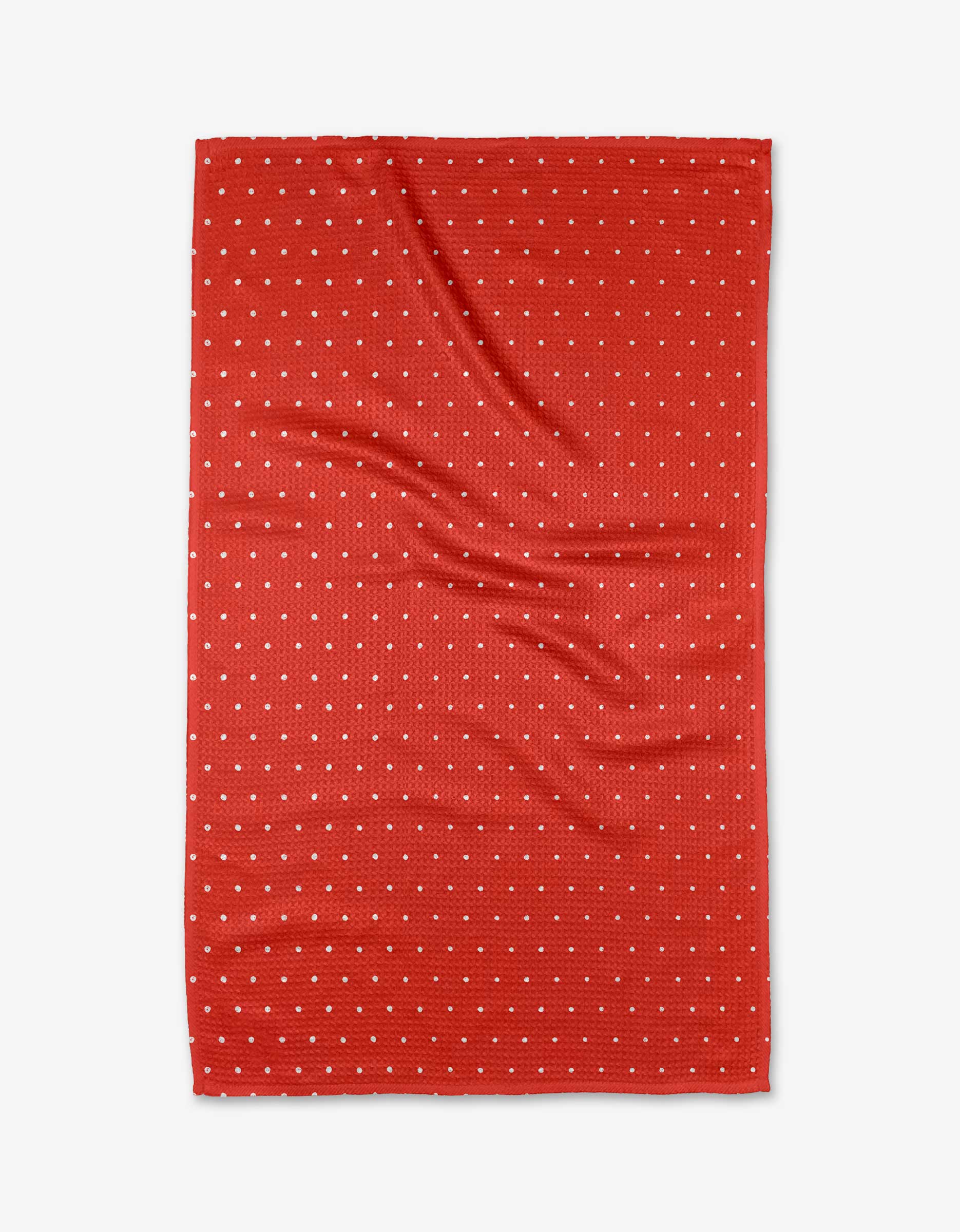 The Kailee Wright Spice kitchen towel is red with a grid of small white polka dots, made from recycled materials. It has a rectangular shape and appears slightly wrinkled, shown flat on a white background.