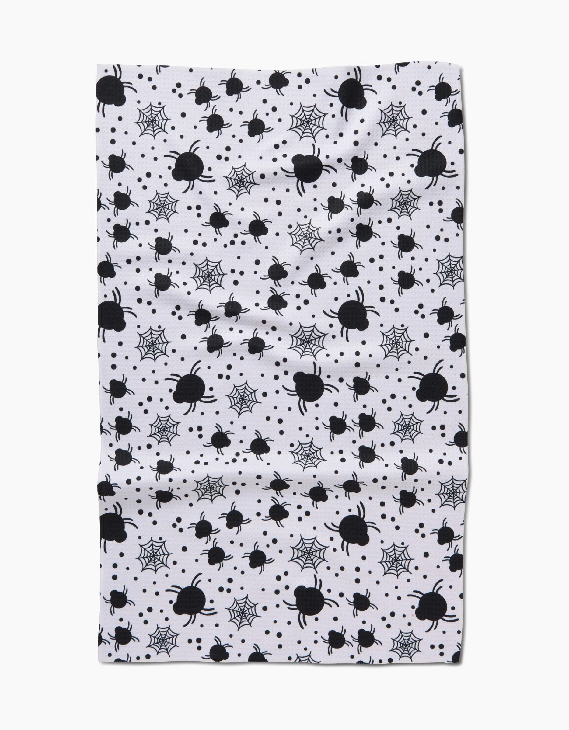 The Spiders For Days tea towel by Charlie Rowan Designs features black spiders, webs, and dots on ultra-absorbent white fabric.