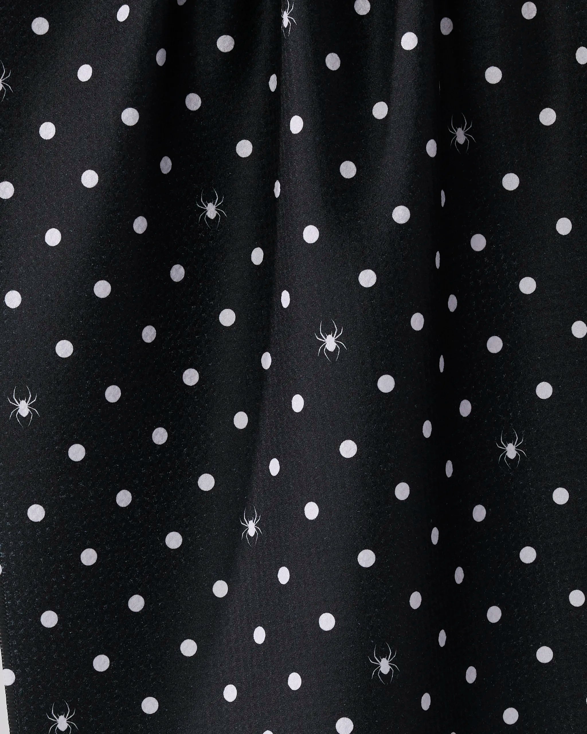 Geometry’s Spookydots is a black kitchen towel made from recycled materials, featuring white polka dots and scattered spider illustrations.
