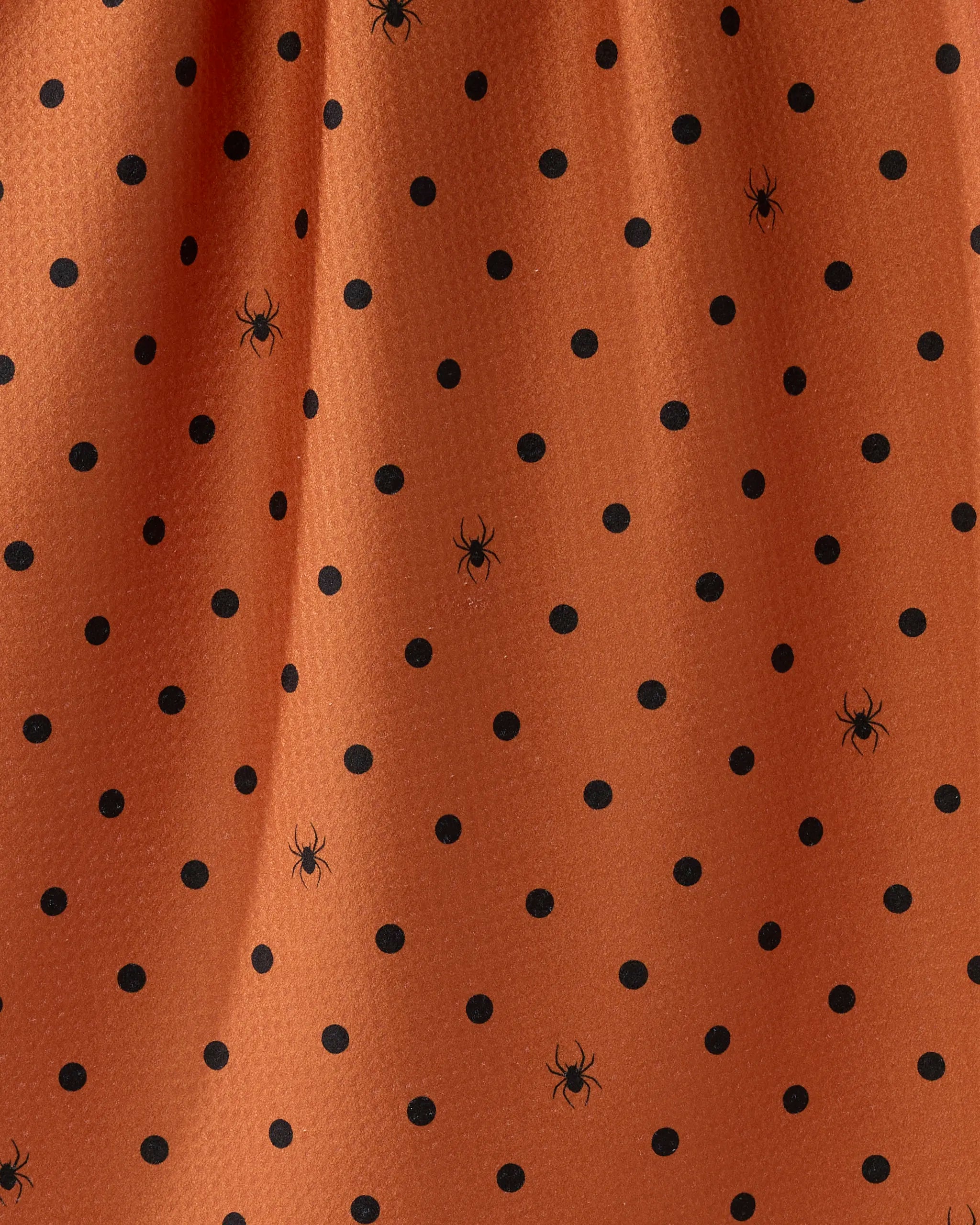 The Geometry Spookydots kitchen towel features orange fabric with black polka dots and spider illustrations, creating a Halloween theme. Made from recycled materials.
