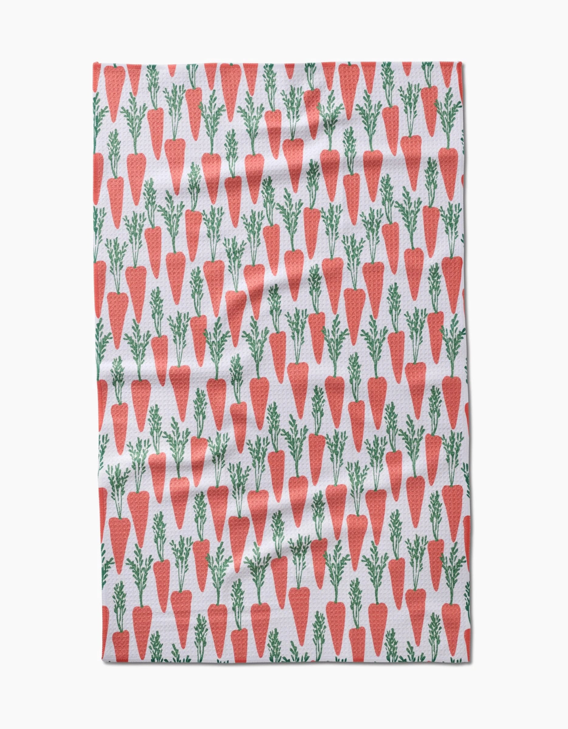 The Spring Carrot Hill tea towel by Hufton Studio displays orange carrots with green tops in neat rows across a white background.