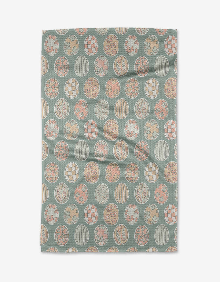 The Spring Easter Eggs kitchen towel by Hufton Studio is a rectangular recycled towel adorned with pastel-colored circular designs featuring floral and geometric motifs on a muted teal background.