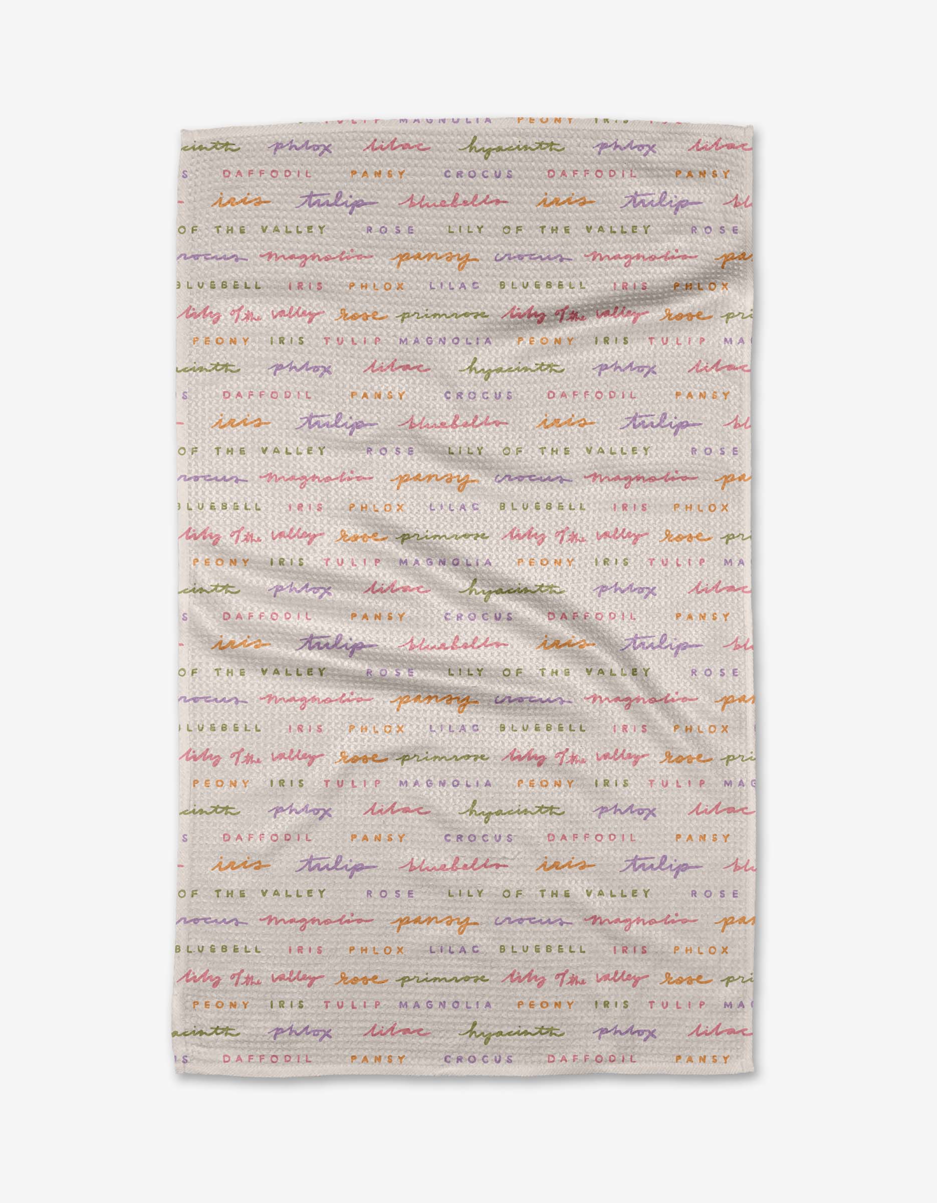 The Spring Flowers by Kayla Ann is a white Geoweave cloth with colorful, cursive names of flowers—daffodil, crocus, lily of the valley, and snowdrop—repeated in horizontal lines.