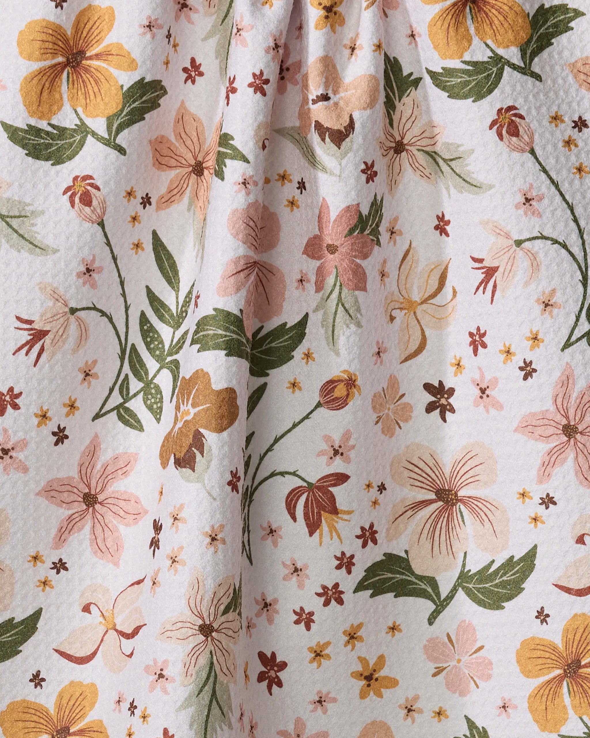 Close-up of the Danelys Sidron "Spring In Devon" tea towel, crafted from recycled materials with hand-drawn yellow, pink, green, and brown flowers and leaves. Ultra-absorbent and softly gathered at the top.