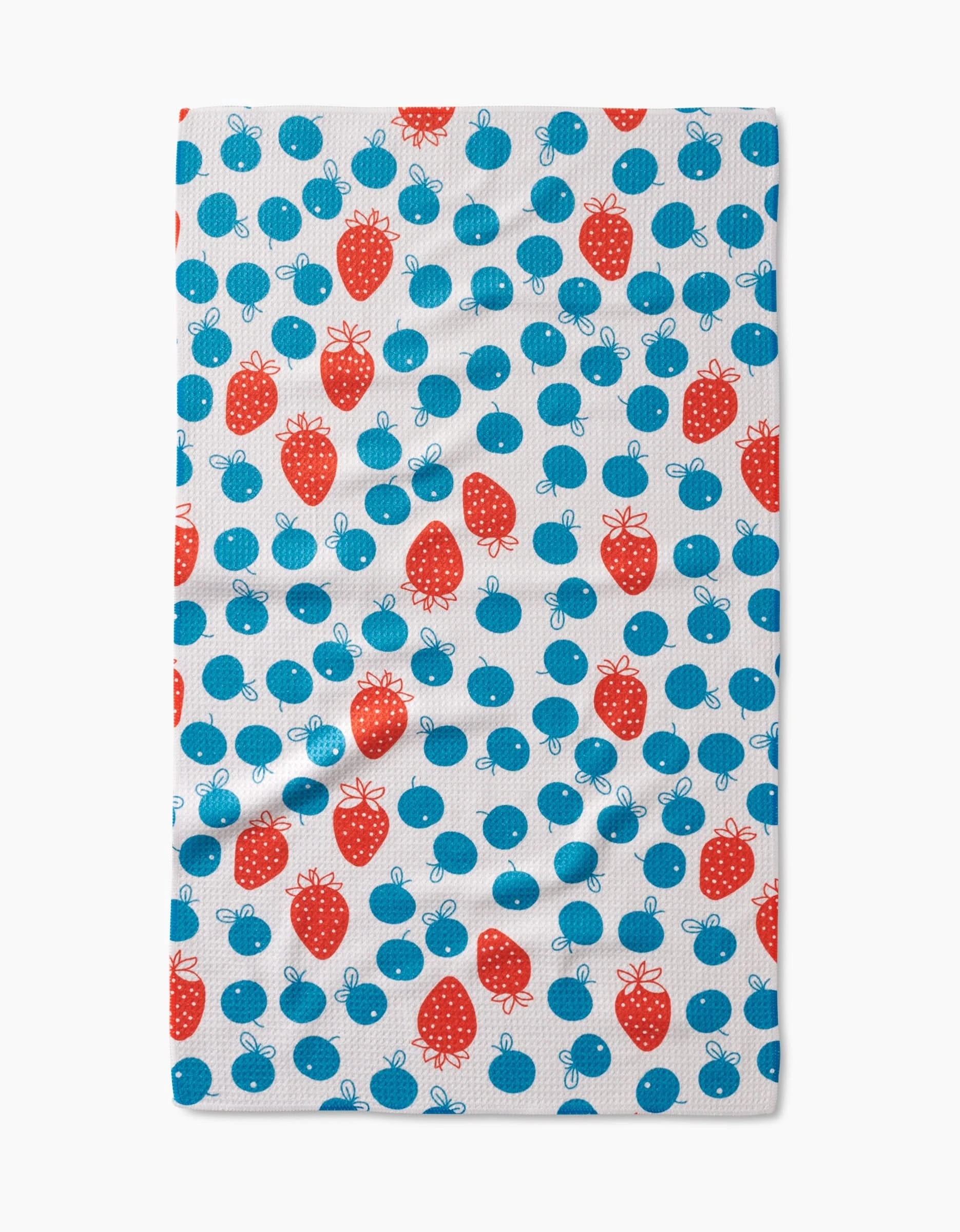 The Sara Mari Star Spangled Berry Tea Towel features a playful, scattered pattern of red strawberries and blue cherries on soft white Geoweave fabric.