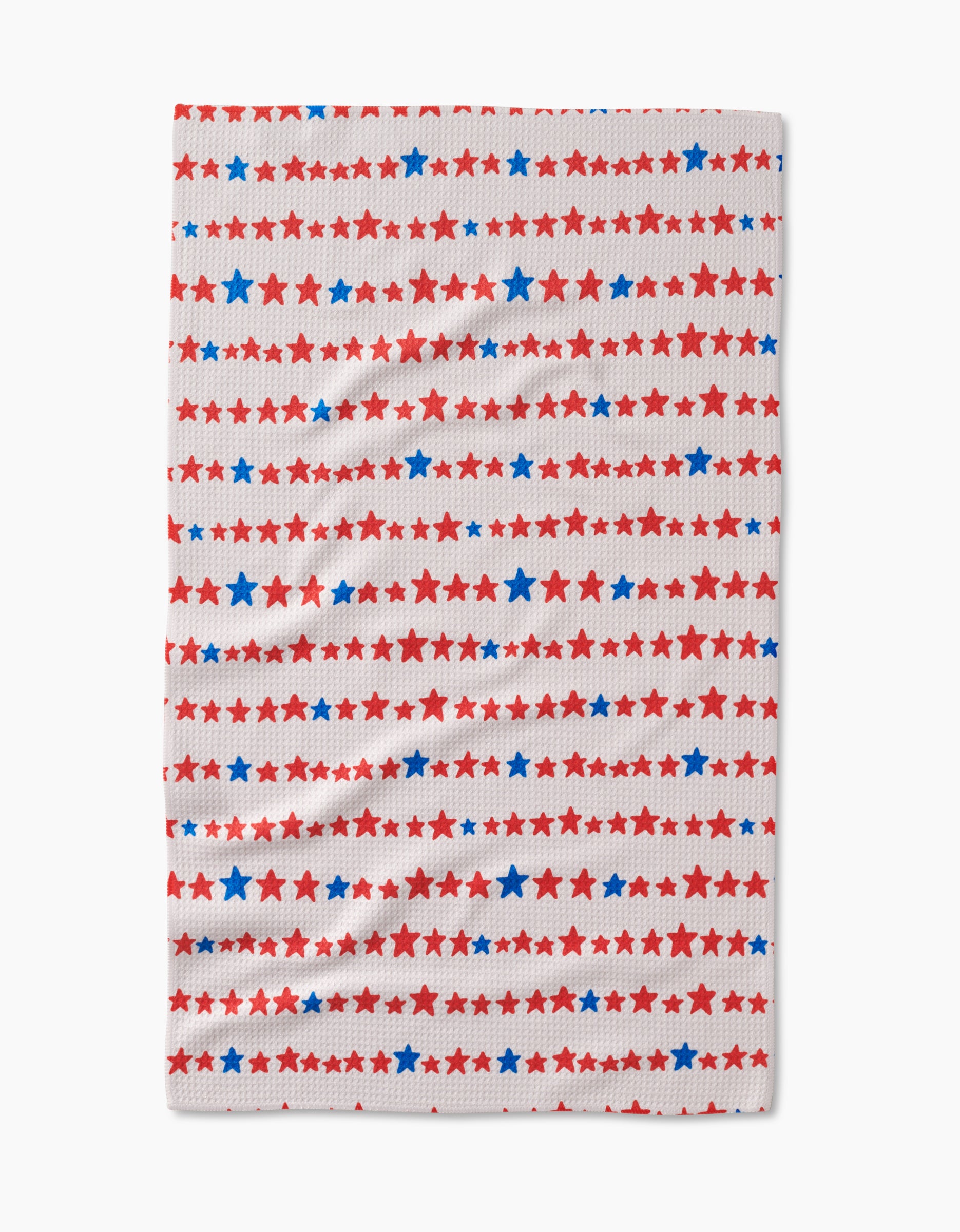The Kayla Ann Starry Stripes Tea Towel features evenly spaced rows of red and blue stars on white Geoweave™ fabric made from post-consumer recycled materials.