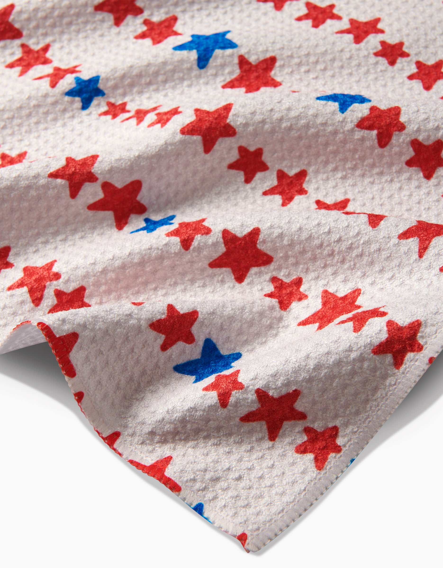 Starry Stripes by Kayla Ann features white textured Geoweave™ fabric adorned with red and blue stars, inspired by the signature Geometry House tea towel design.