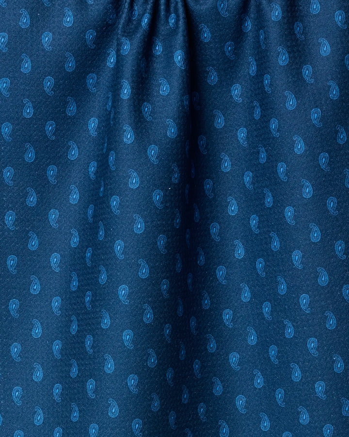 Close-up of Geometry’s Stirrup Indigo: blue fabric made from recycled materials, featuring a lighter blue repeating paisley pattern with subtle folds and gathered texture at the top.