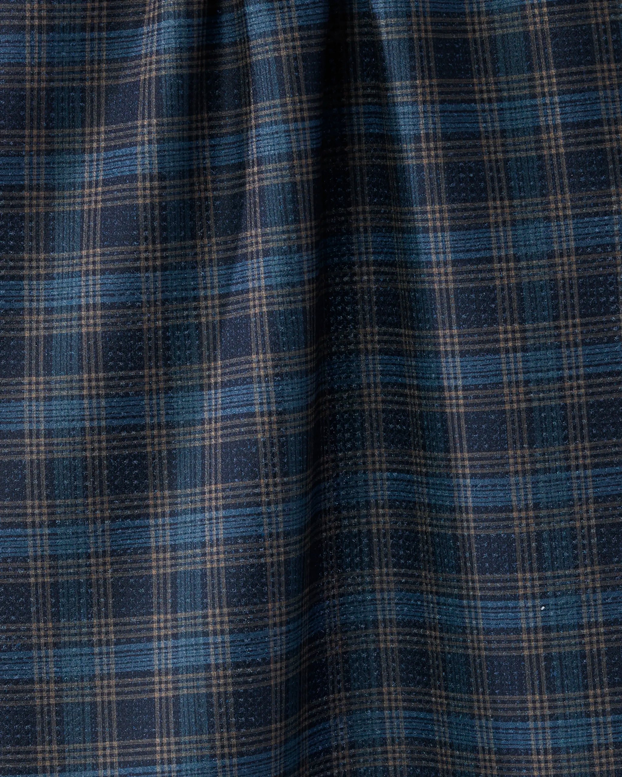 Close-up of Stonegate kitchen towel by Geometry, featuring blue and brown plaid fabric with checkered stripes, highlighting the folds and textured eco-friendly material.