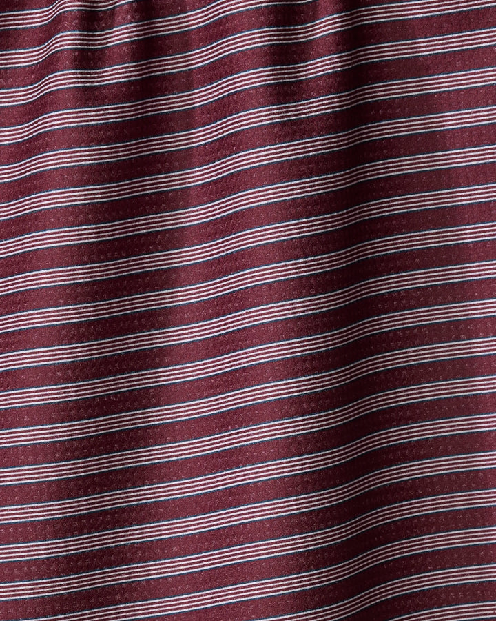 The Buy Guide’s Straight Across - Wine tea towel features maroon fabric with thin, evenly spaced horizontal white stripes. Made from recycled materials, its ultra-absorbent surface displays gentle folds and subtle shadowing.