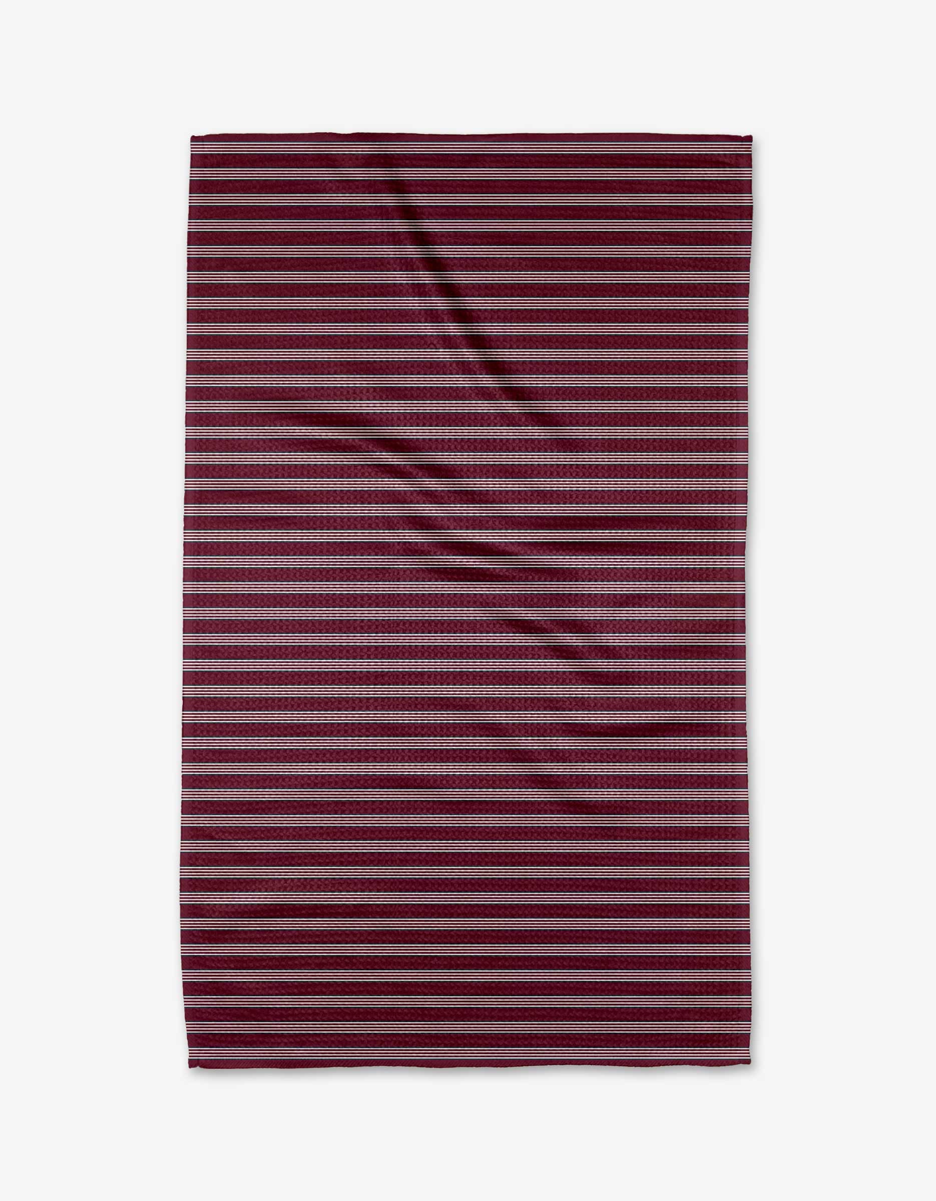 The Buy Guide’s Straight Across - Wine is a rectangular blanket made of ultra-absorbent Geoweave fabric with horizontal maroon, burgundy, and dark gray stripes on a white background and a slightly wrinkled texture.