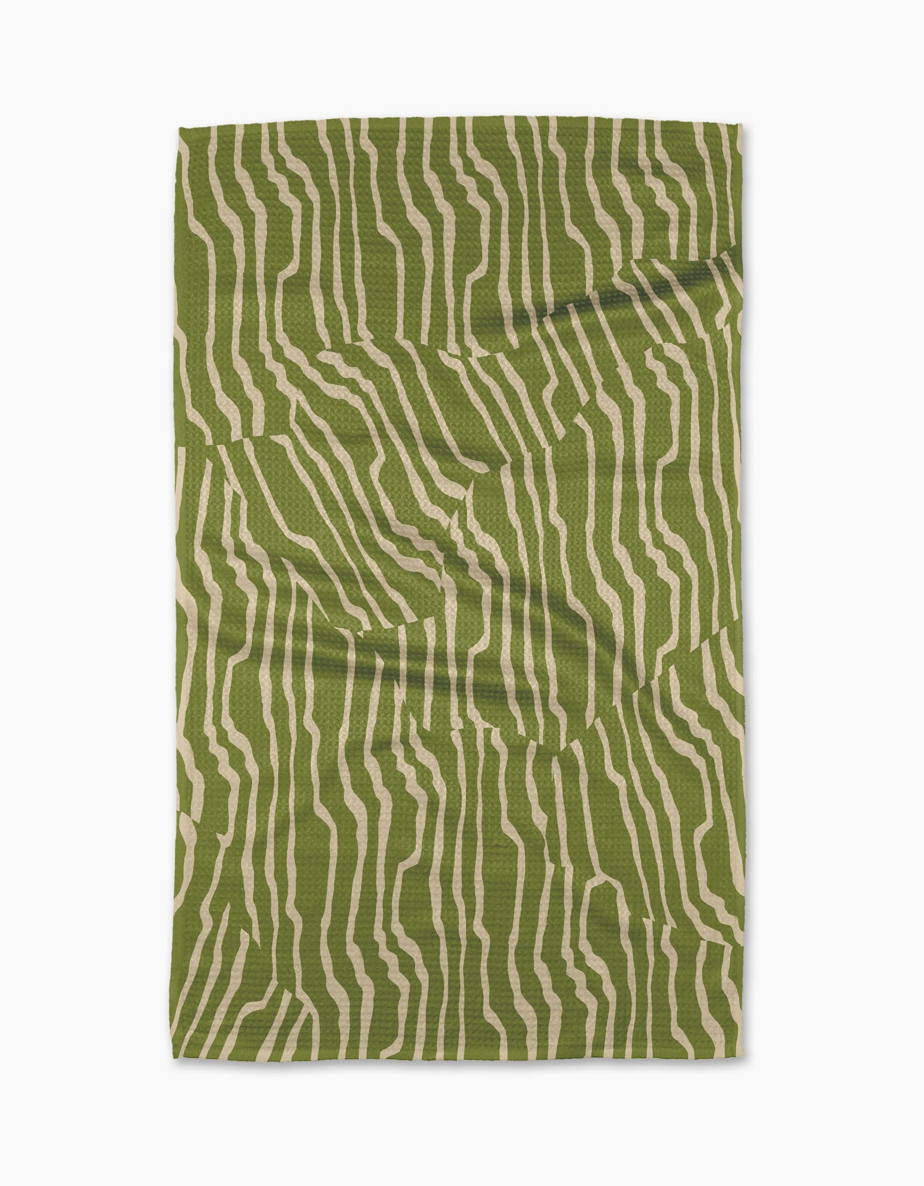The Geometry Stripe Funk Grounds Green blanket, featuring an abstract green and beige wavy stripe pattern, is crafted from soft Geoweave fabric and shown laid flat on a white background.
