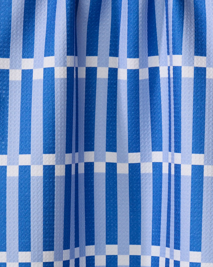 Stripe Block - Blues by The Buy Guide features blue and white checkered fabric with vertical and horizontal stripes in a grid pattern, a subtly textured finish, and soft folds gathered at the top.