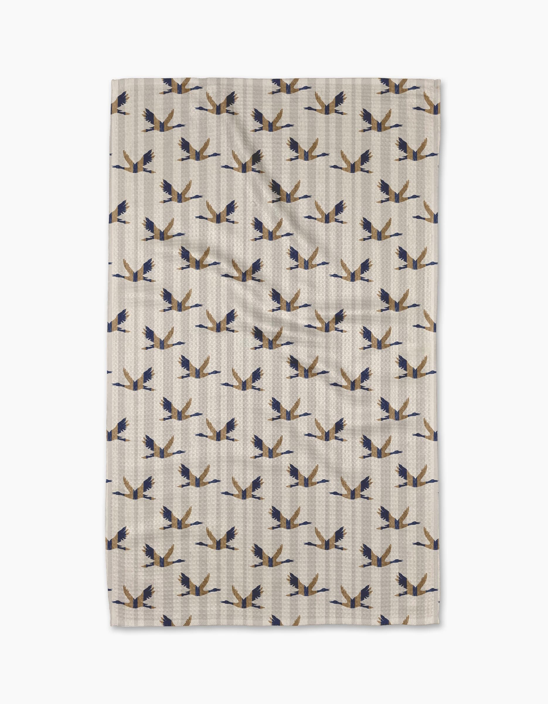 The Geometry Striped Nautical Birds blanket, made from recycled materials, features blue, black, and tan stylized birds facing various directions on beige, shown flat against a white background.
