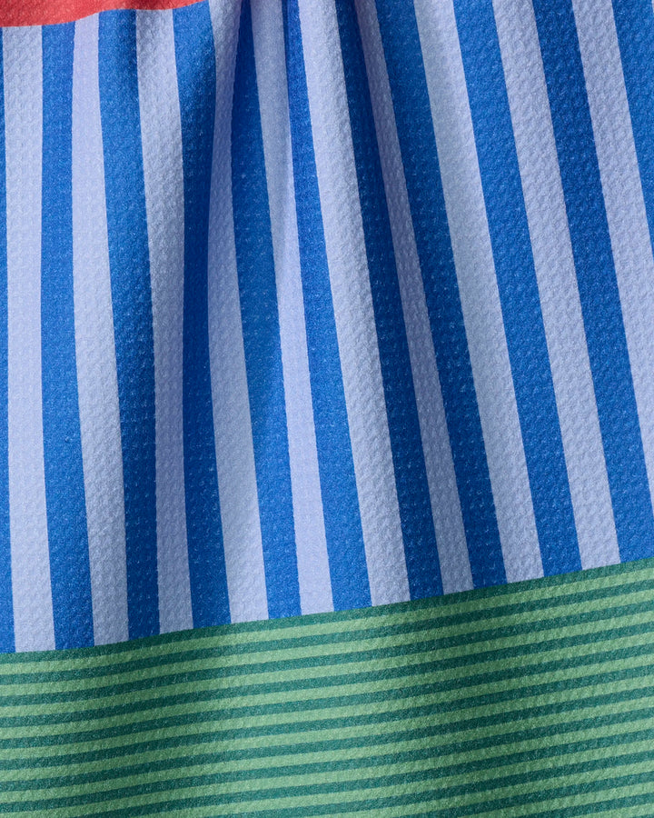 Close-up of The Buy Guide’s Stripes on Stripes dish towel, featuring absorbent fabric with blue and white vertical stripes, a green striped band along the bottom, and a subtle touch of red at the top.