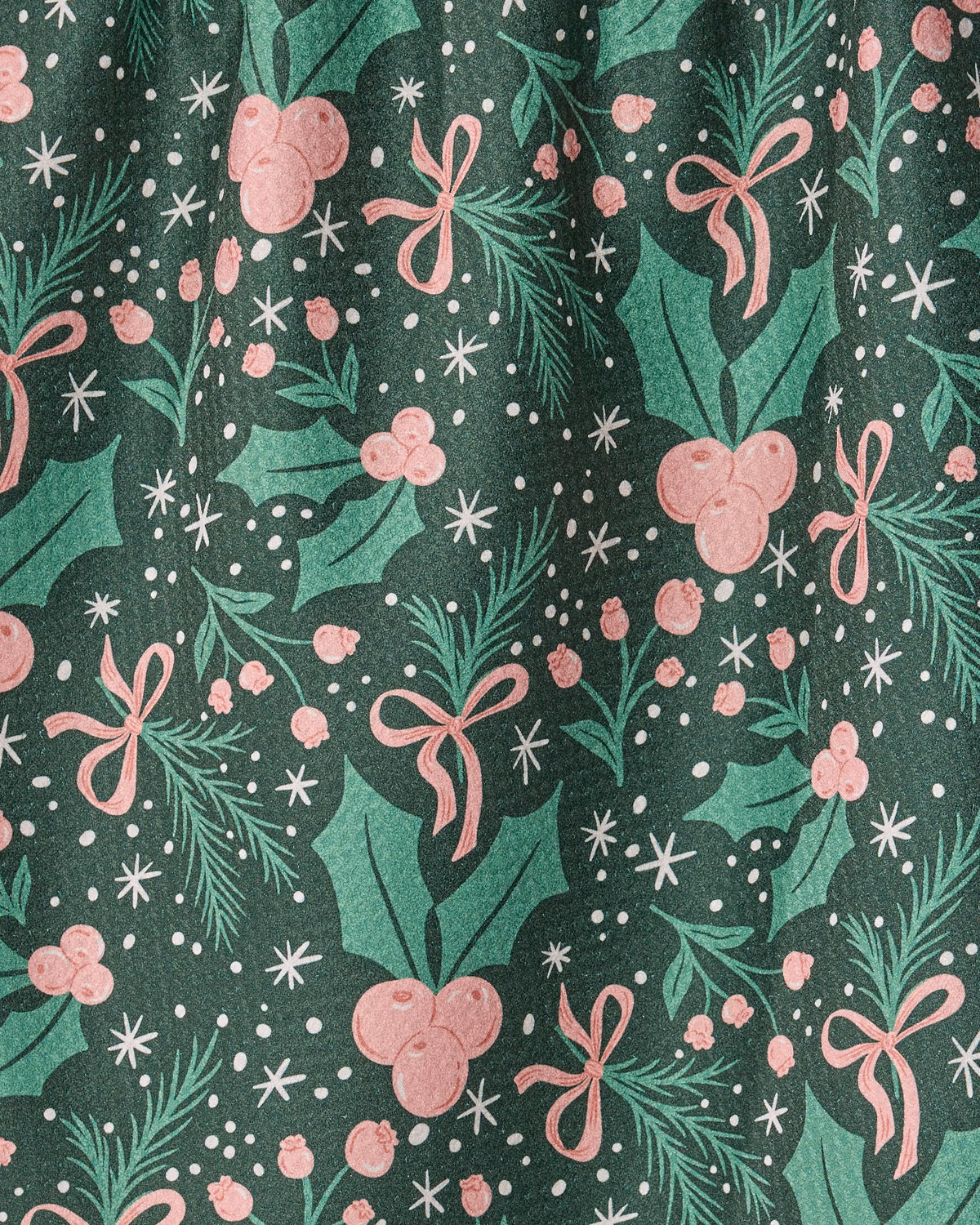 The Geometry “Sugarplum Florals” kitchen towel features a green background adorned with a festive pattern of pink bows, holly leaves, berries, pine branches, and scattered white dots and stars. Crafted from recycled materials, it beautifully evokes a cheerful holiday or Christmas spirit.
