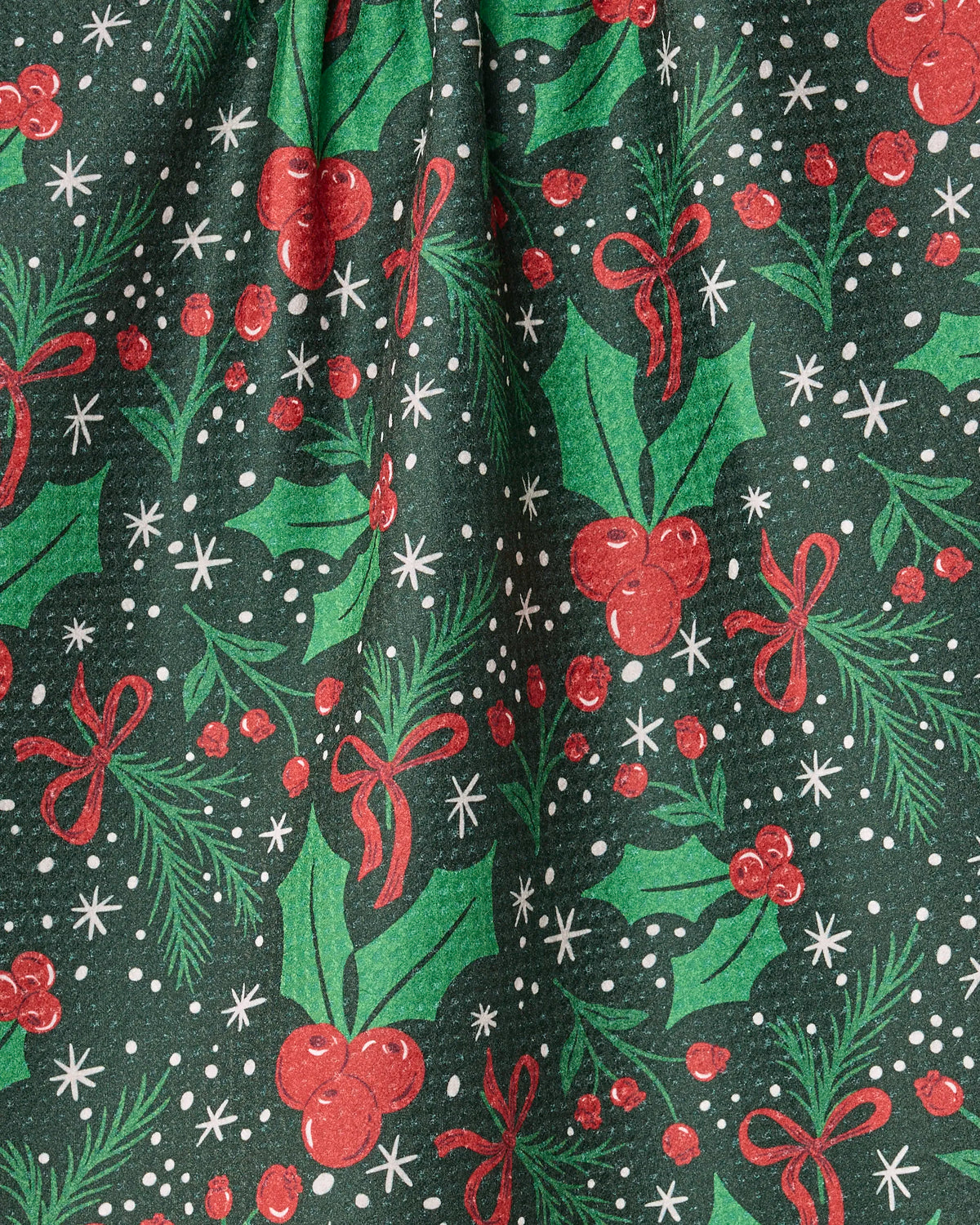 Sugarplum Florals by Geometry features green Geoweave fabric adorned with a festive pattern of holly leaves, red berries, red bows, white snowflakes, and pine branches—evoking a cheerful Christmas or holiday spirit—perfect for an eco-friendly tea towel made from recycled materials.