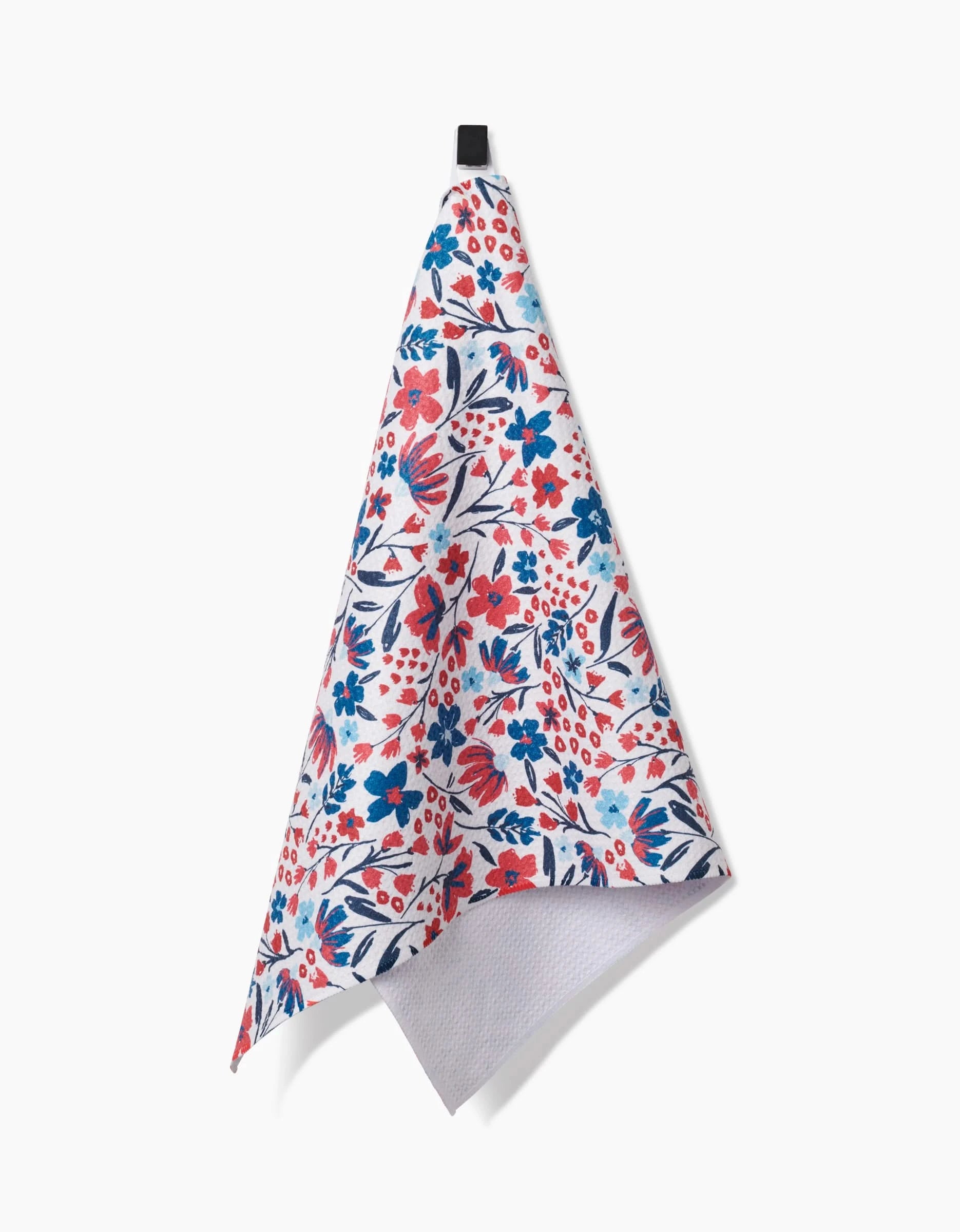 The Summer Bloom Tea Towel by Hufton Studio features a vibrant red, blue, and pink floral pattern on white, made from recycled materials. It hangs from a black loop against a plain white background.