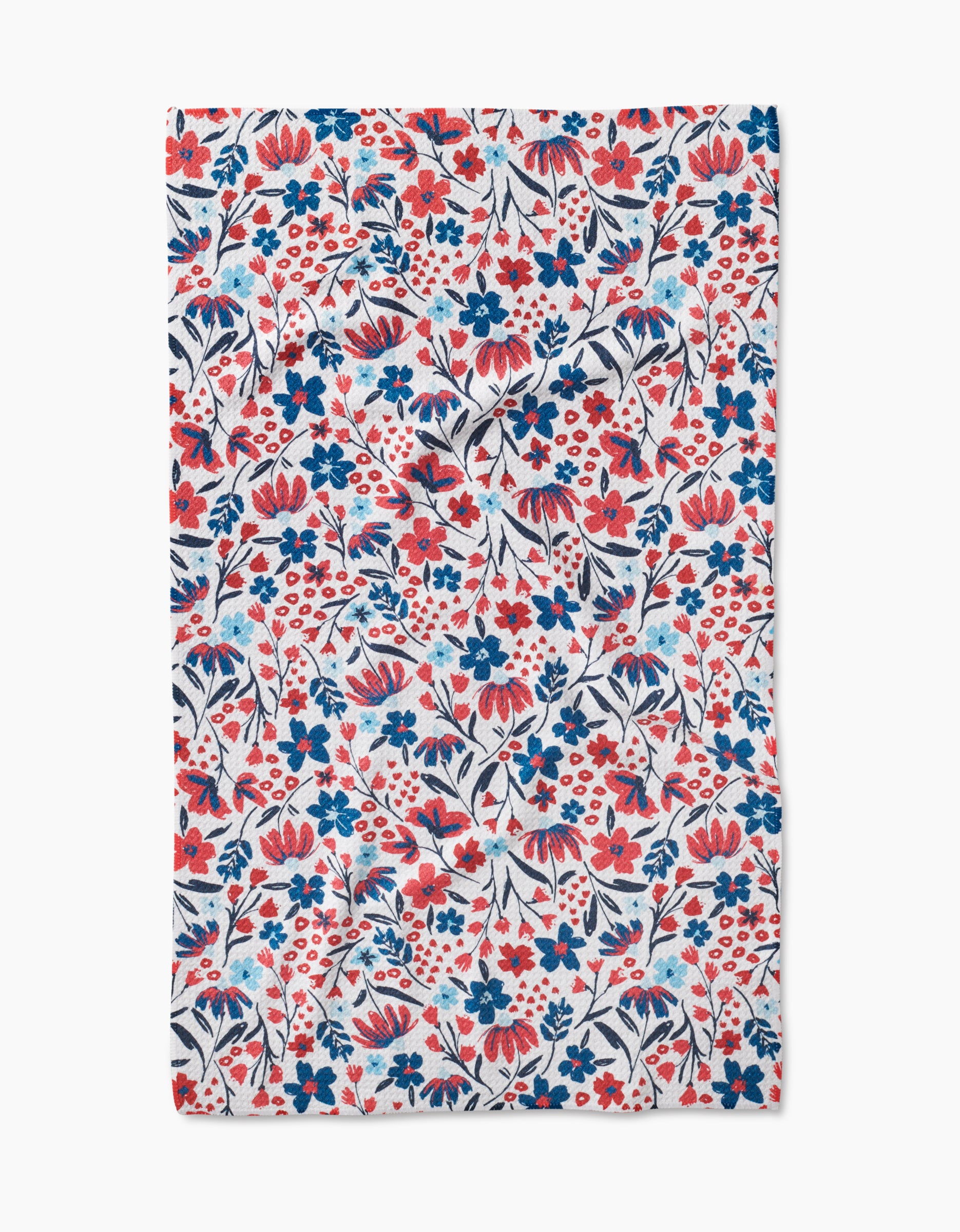 The Summer Bloom tea towel by Hufton Studio is made from Geoweave fabric and features a lively, dense floral pattern with red, blue, and navy flowers and leaves on a white background.