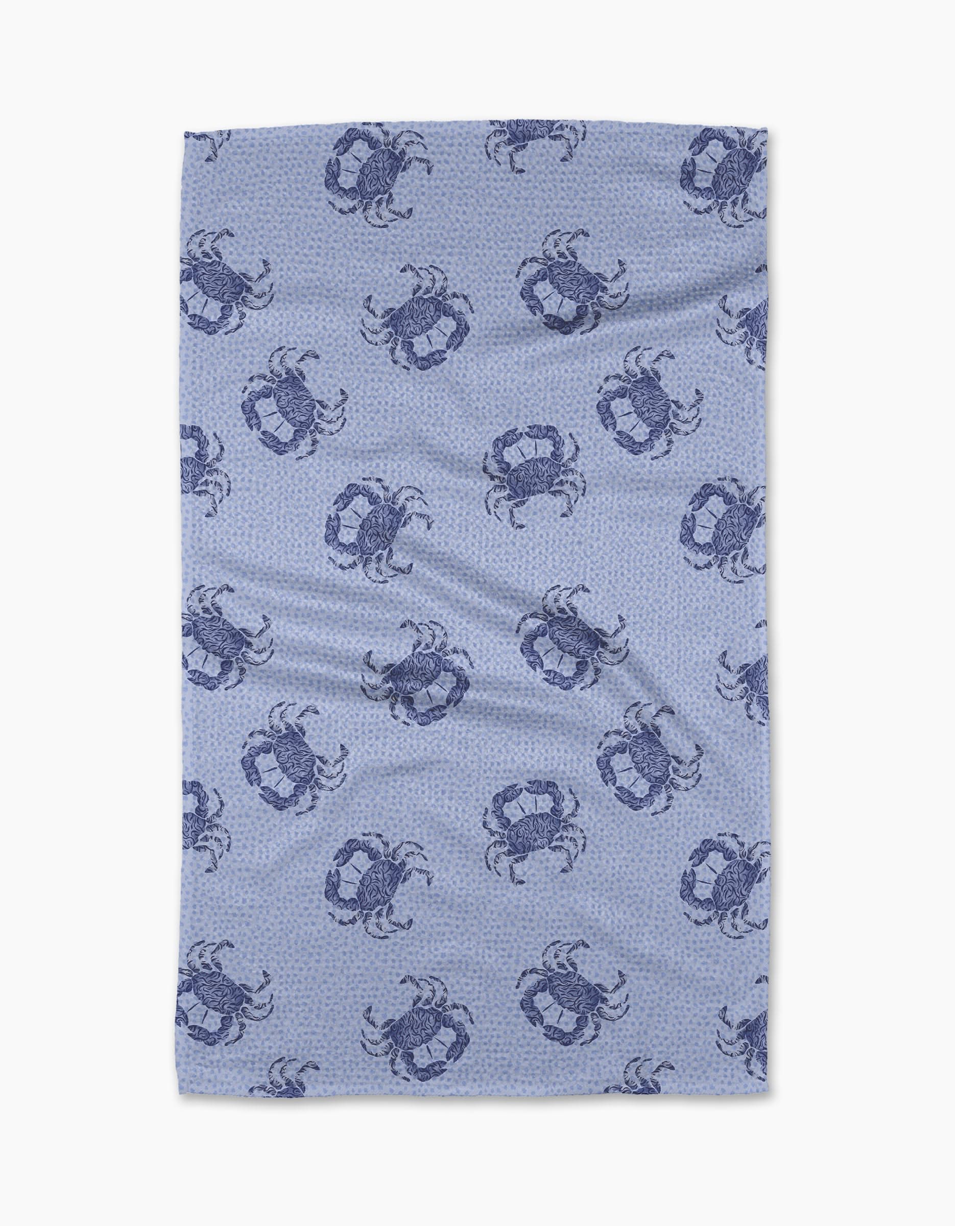 The Geometry Summer Crabs Tea Towel features dark blue crabs on a light blue, subtly dotted background. Made from eco-friendly material, it has a slightly wrinkled look and is shown on a white surface.