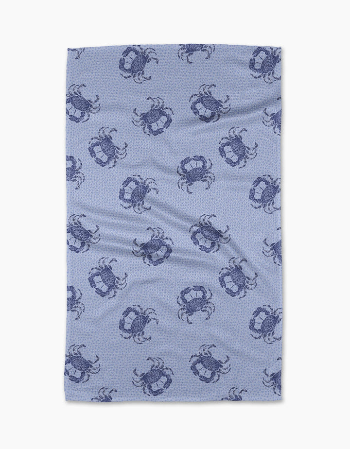 The Geometry Summer Crabs Tea Towel features dark blue crabs on a light blue, subtly dotted background. Made from eco-friendly material, it has a slightly wrinkled look and is shown on a white surface.