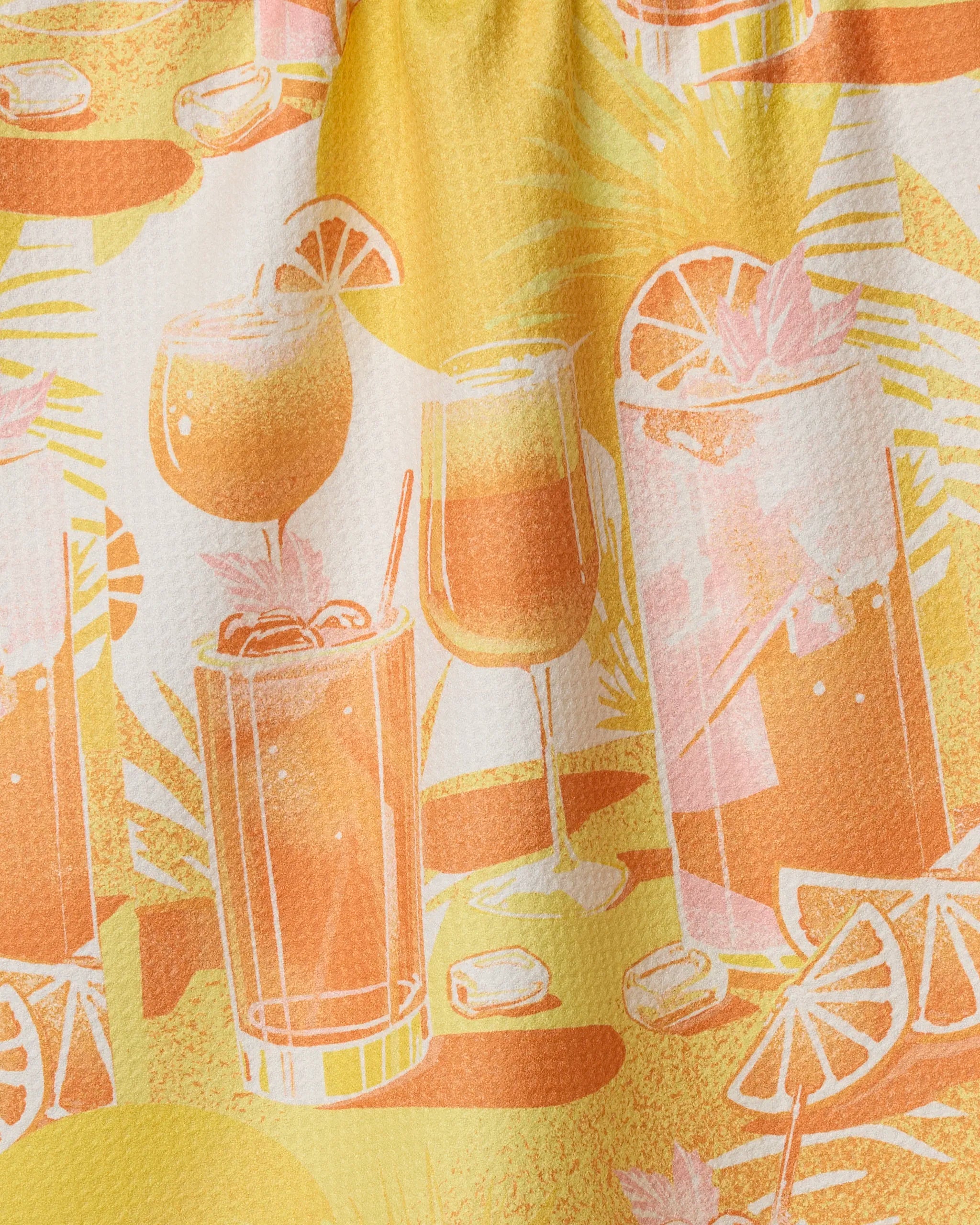 The Geometry "Sunset Happy Hour" dish towel features a vibrant pattern of tropical cocktails, ice cubes, citrus slices in orange, yellow, and pink hues, and leafy backgrounds—perfect for brightening your kitchen.