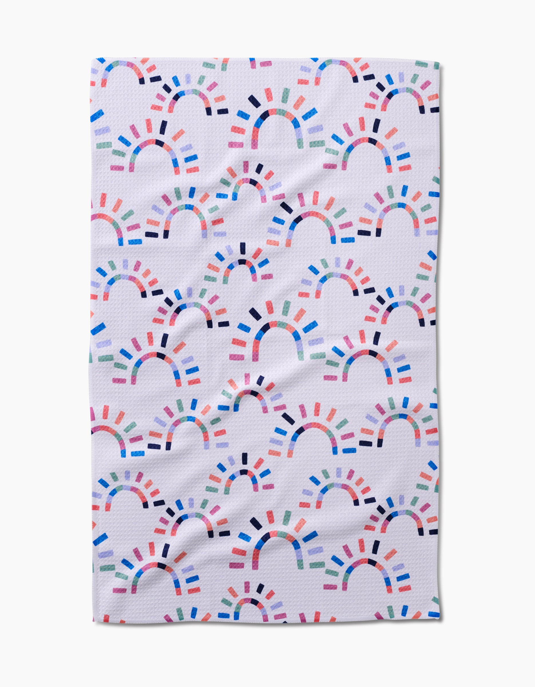 The Sunshine Rainbow towel by Claire Iglesias features a white textured design with colorful, semi-circular rainbow shapes and is crafted from ultra-absorbent Geoweave fabric for superior performance.