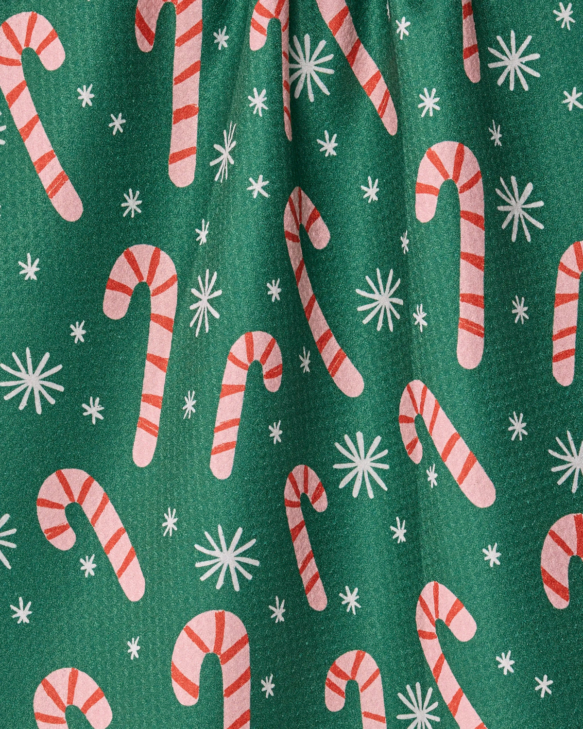 The “Sweet Candy” tea towel by Geometry features green fabric adorned with a festive pattern of red and white candy canes and white snowflakes. Quick-drying and practical, it’s a cheerful way to add holiday spirit to your kitchen.