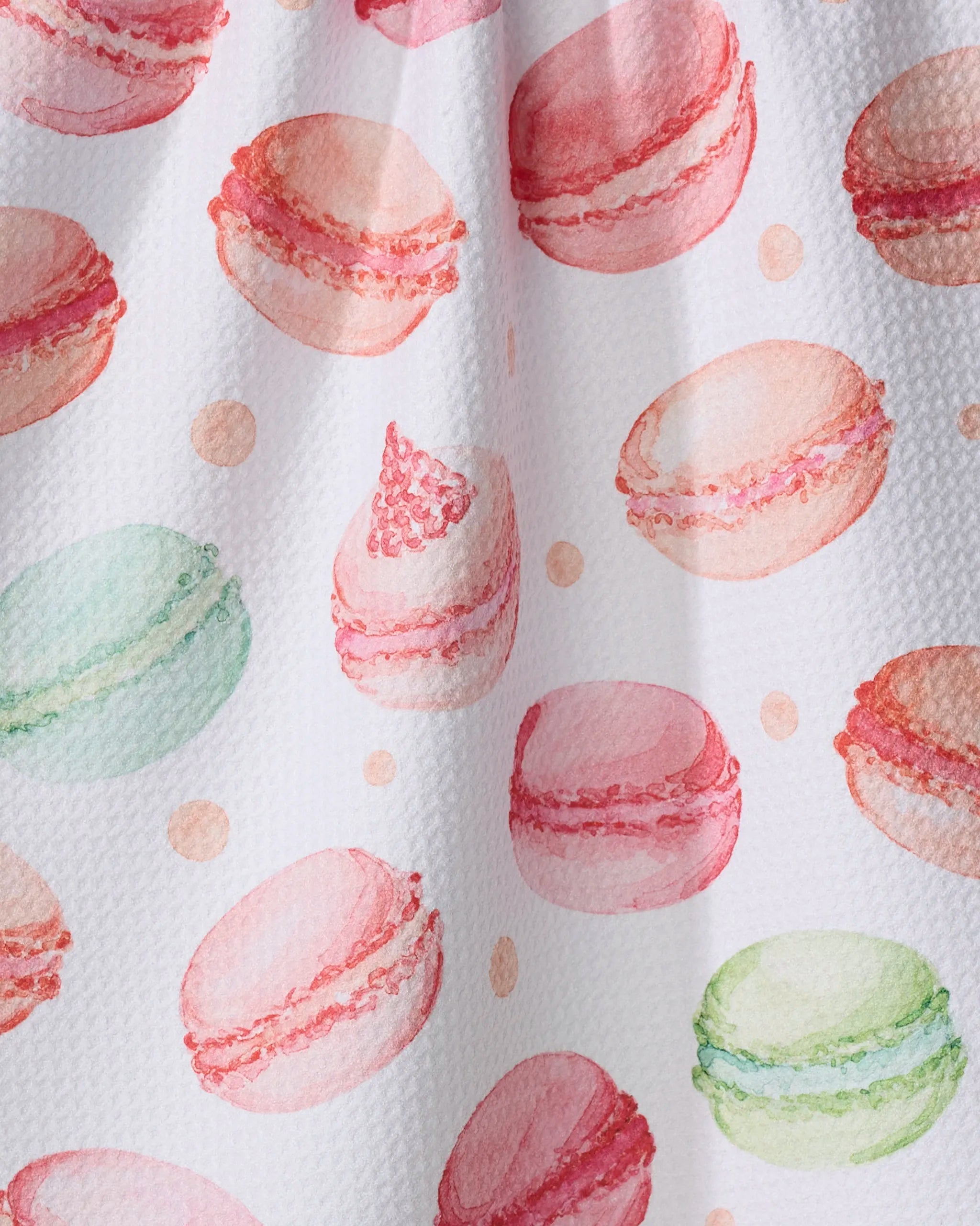 Seventies Retro Flowers by Claire Iglesias: a watercolor illustration featuring pink, green, and peach macarons scattered on a white recycled kitchen towel with small dots between them.