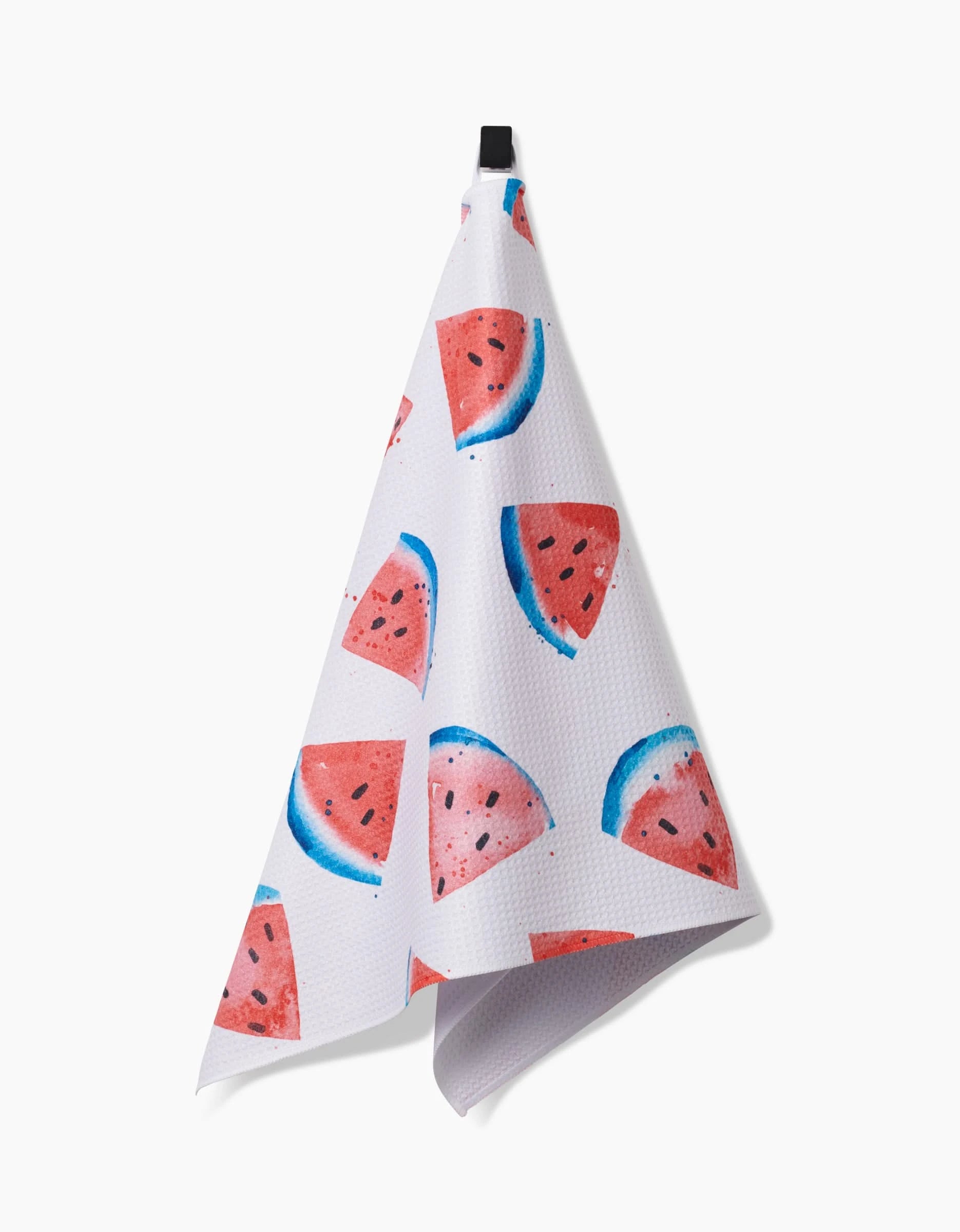 The Sweet Slice Of July tea towel, made from recycled materials, features a vibrant watermelon slice pattern and hangs by a black loop against a plain white background.