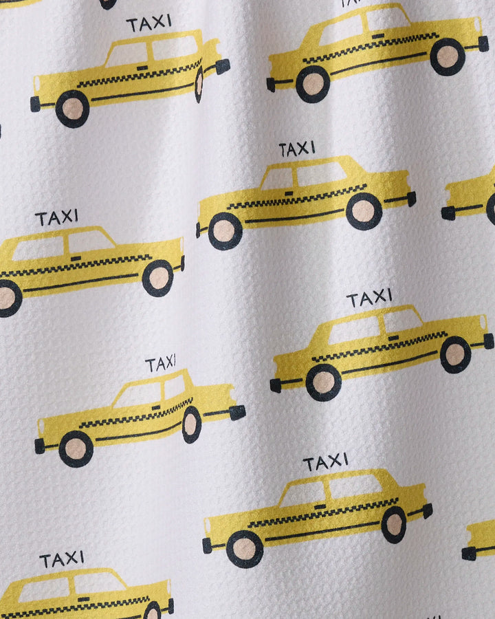 The Taxi Cabs tea towel by Vaishali Design Studio features a simple, cartoon-style pattern of yellow taxi cabs with "TAXI" above each car on a white background.