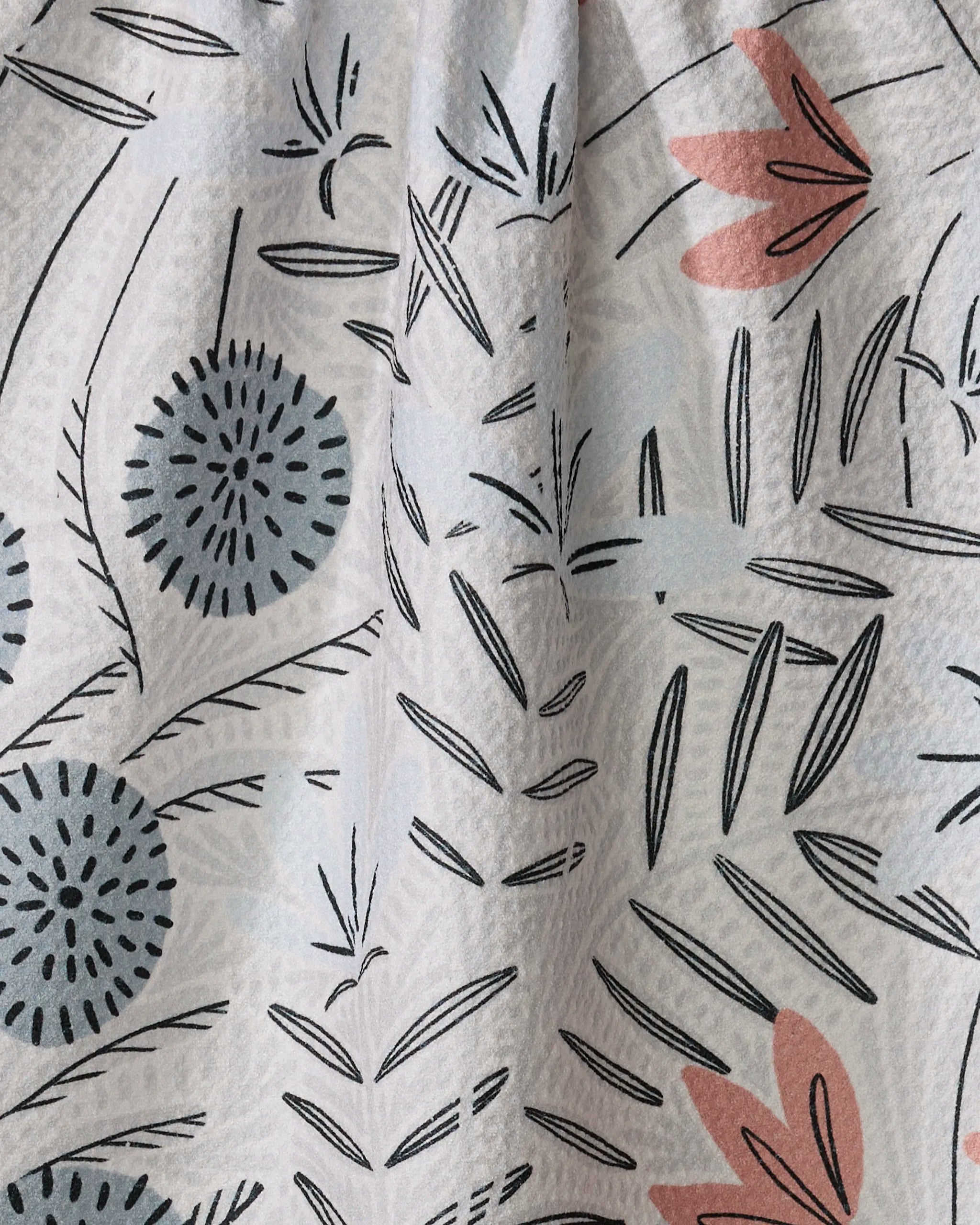 Teagan Cream by Amy MacCready features a light background with blue circular flowers, pink abstract petals, and black leafy lines in a scattered nature-inspired pattern—ideal for a quick-drying dish towel.