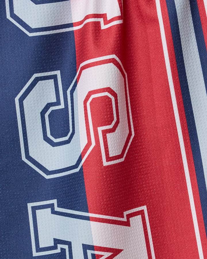 Close-up of Geometry's Team USA fabric, featuring blue and red vertical stripes from recycled materials, with large white outlined numbers 2 and 4 partly visible, evoking a sports jersey look.