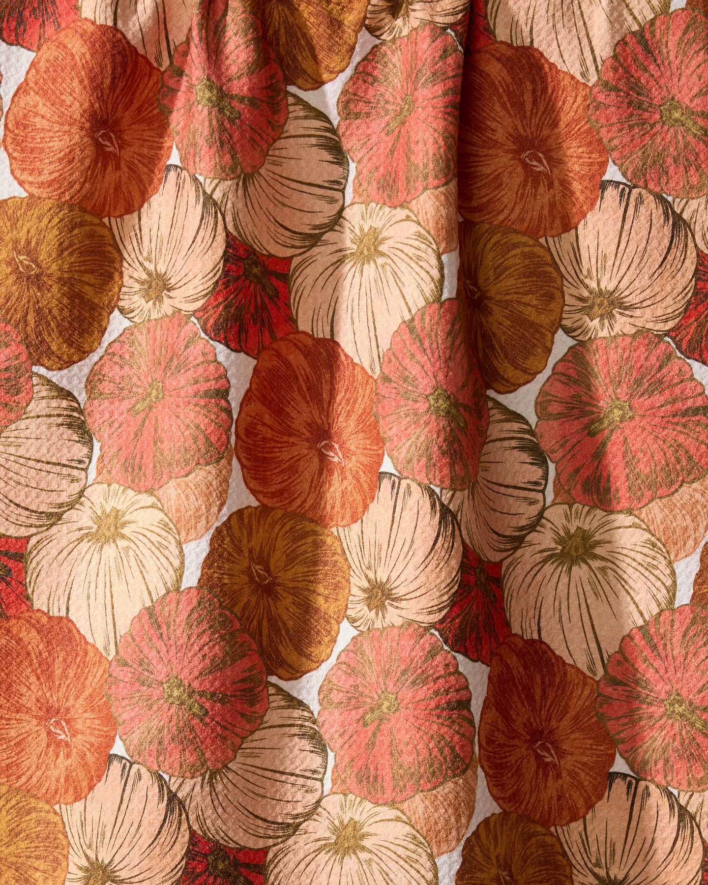 The Geometry Tendril kitchen tea towel features overlapping pumpkins in orange, rust, cream, and gold with detailed lines and textures.