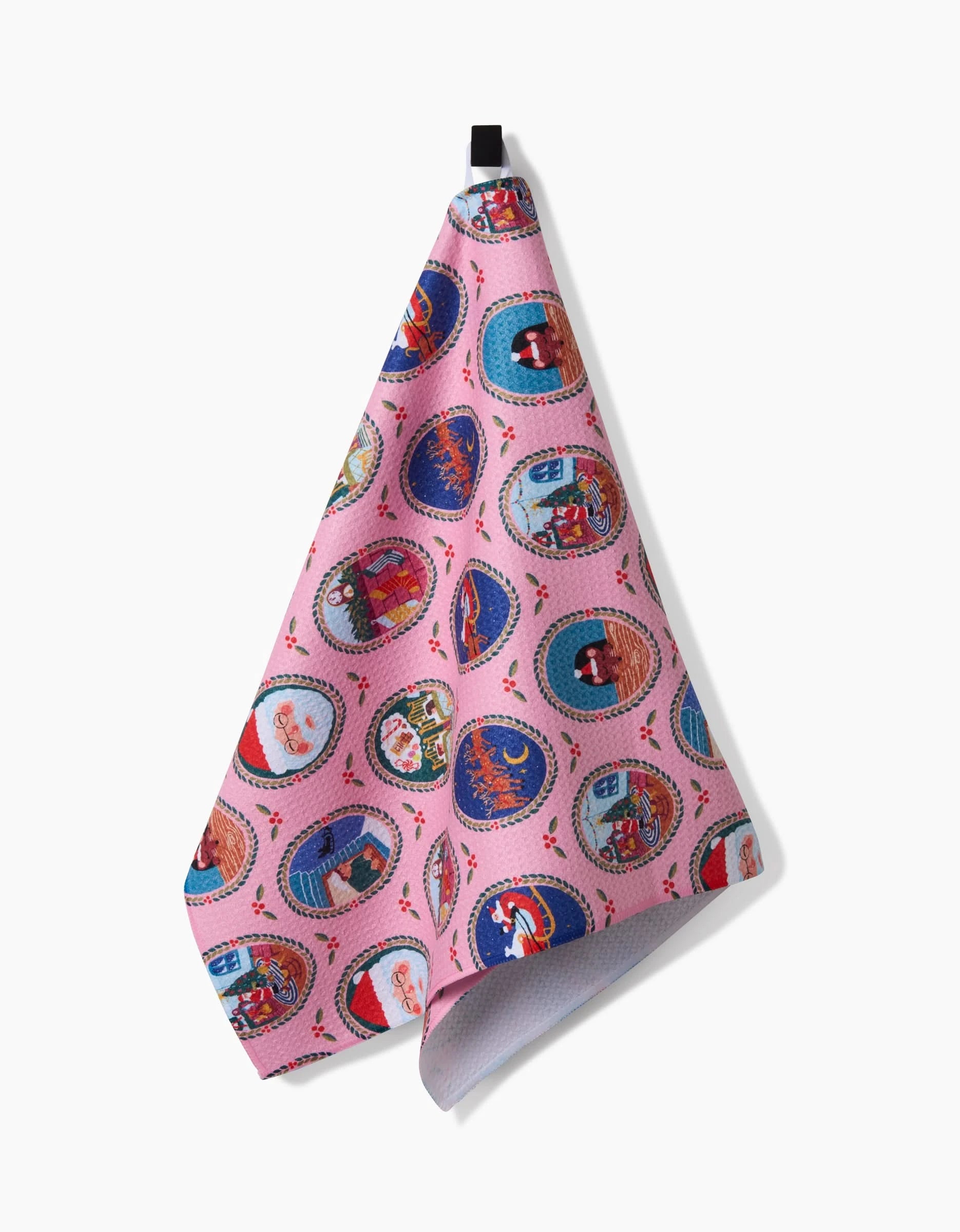 The Night Before Christmas kitchen towel by Elisabeth Wing features colorful, circular animal illustrations and whimsical designs on pink recycled fabric, hanging from a black loop against a white background.