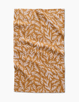 The Trail Dusting Gold napkin by Twig + Spark features a rectangular, wrinkled design with a mustard yellow background and white leafy branches, crafted from recycled materials for an eco-friendly touch.