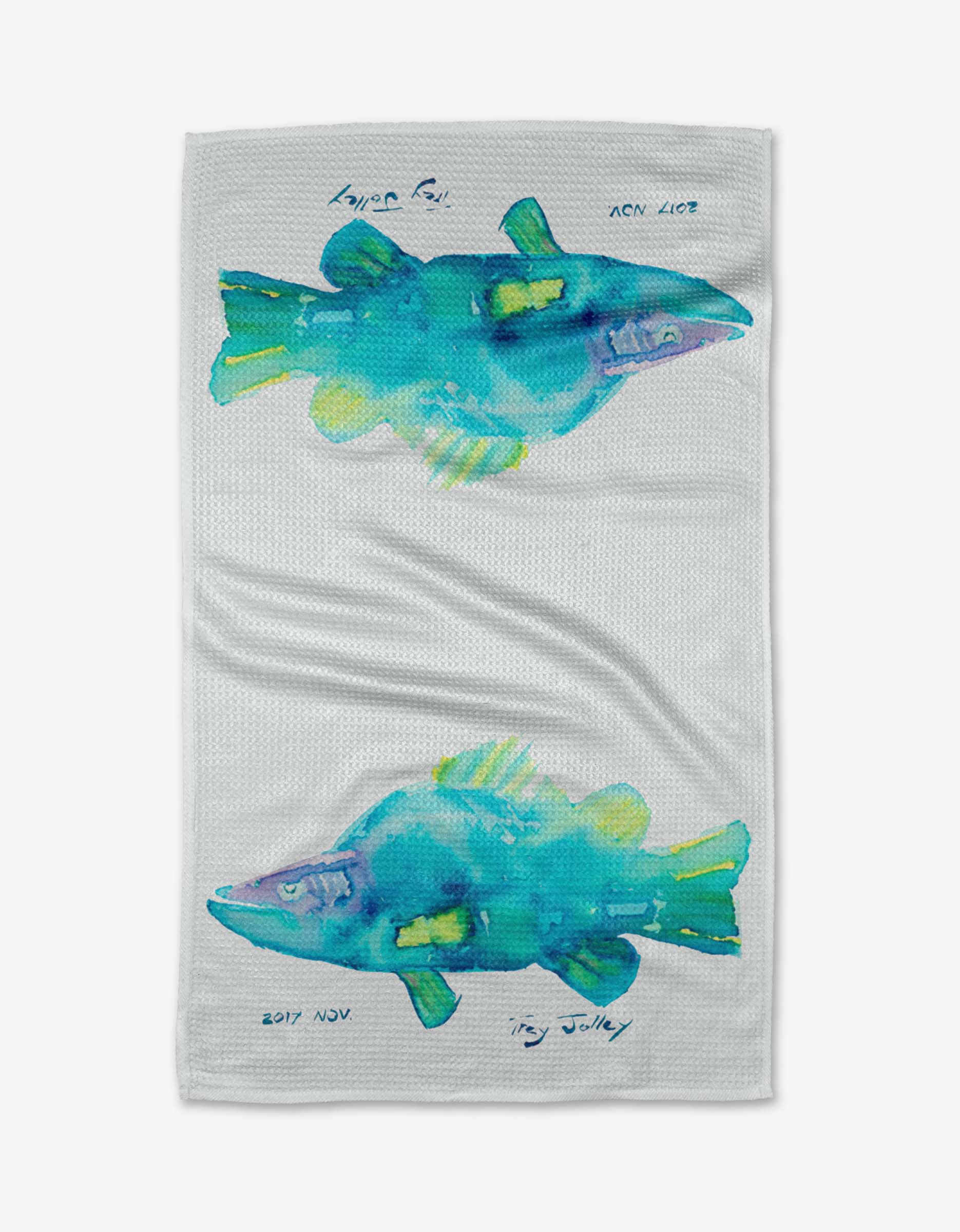 Tropical Twins by Trey Jolley: a white Tea Towel with two watercolor-style fish in blue, green, and yellow, facing opposite ways. Made of Geoweave™ fabric from post-consumer recycled materials. Handwritten text and dates near each fish.