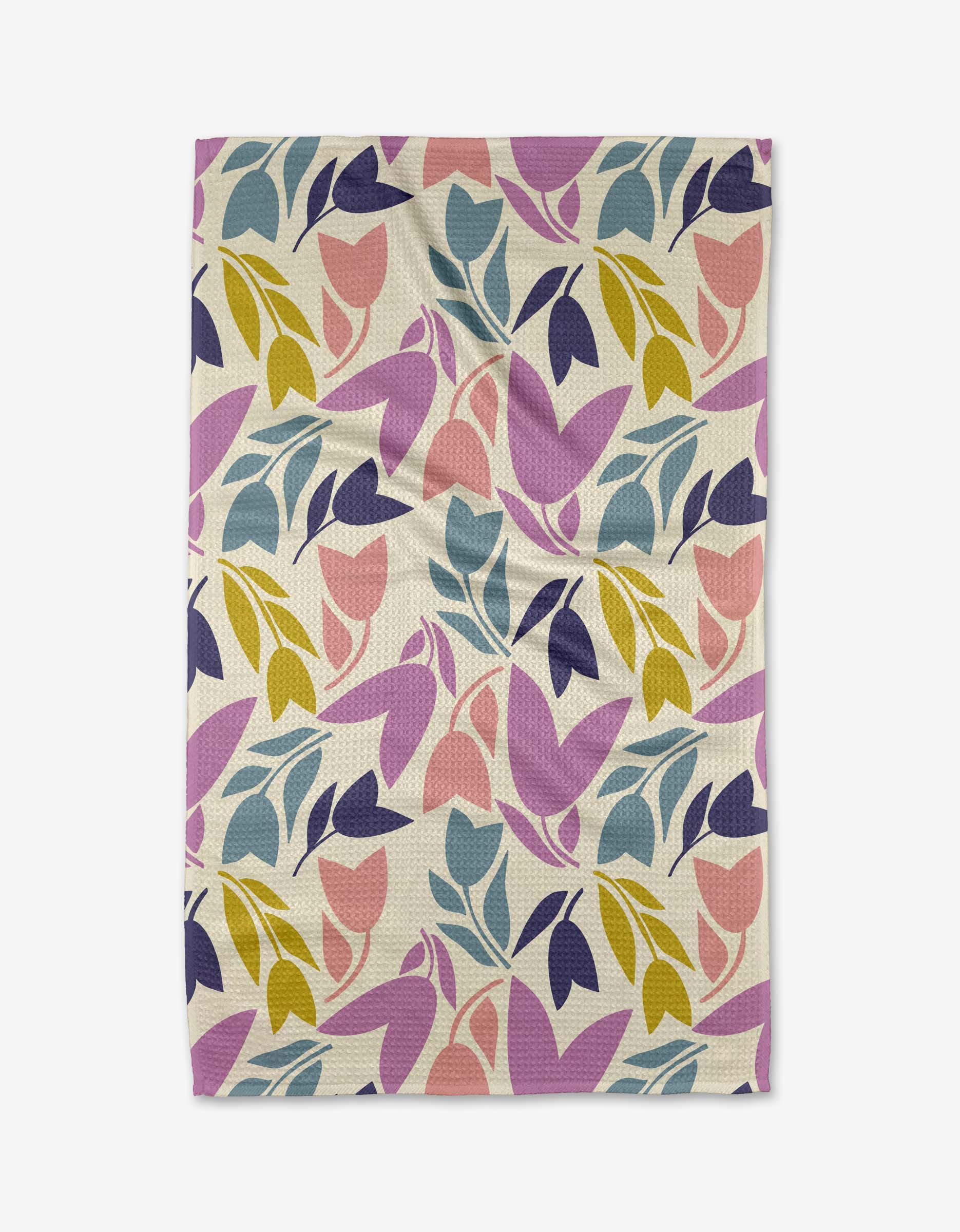 The Tulip Tumble tea towel by Lizzie Clark is made from recycled materials and showcases a vibrant abstract leaf and flower design in pink, purple, blue, and yellow on a white background.