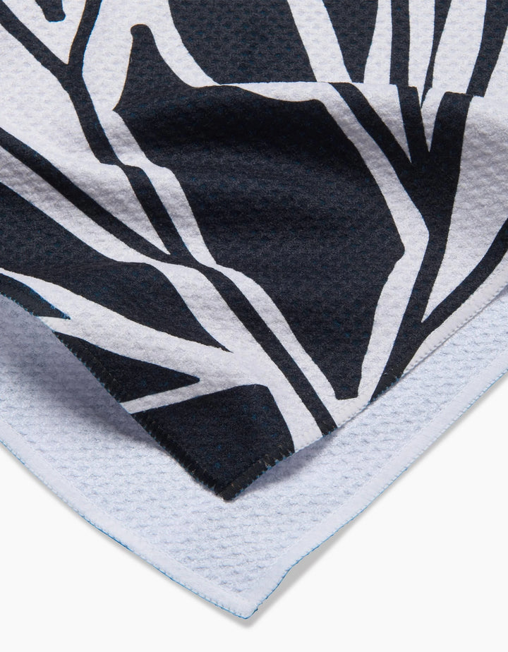 Close-up of Ash Cascades Twilight Plant kitchen towel, featuring a black and white abstract botanical pattern on eco-friendly, textured fabric with neatly stitched edges.